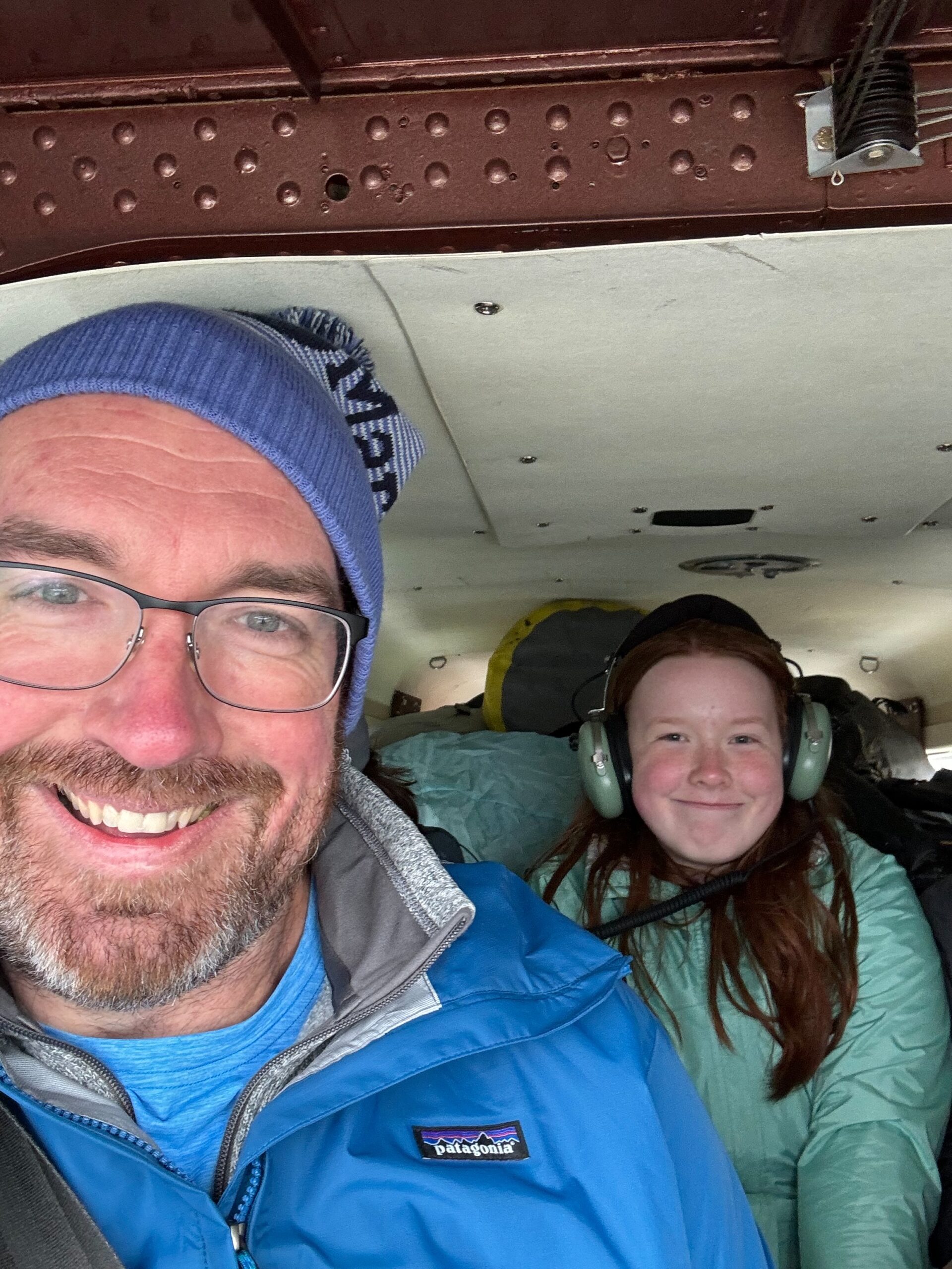 Cameron sitting in the middle seat on the second row, and me in the right hand front seat of a de Havilland Beaver flying back to Lake Clark. 