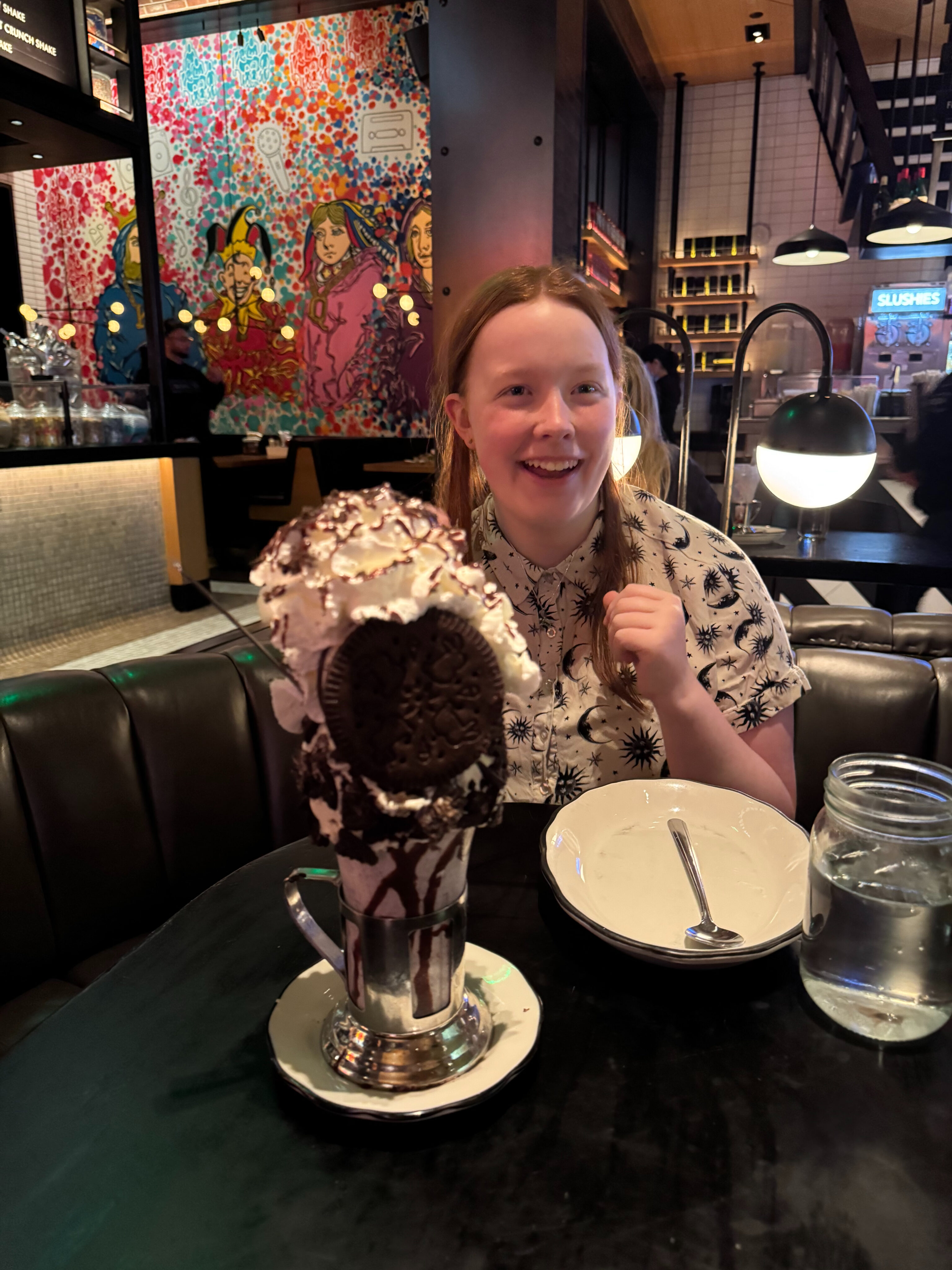 Cameron on her 16th birthday sitting in a both at the The Black Tape Craft Burgers and Beer in Las Vegas with a massive Oreo Milkshake.