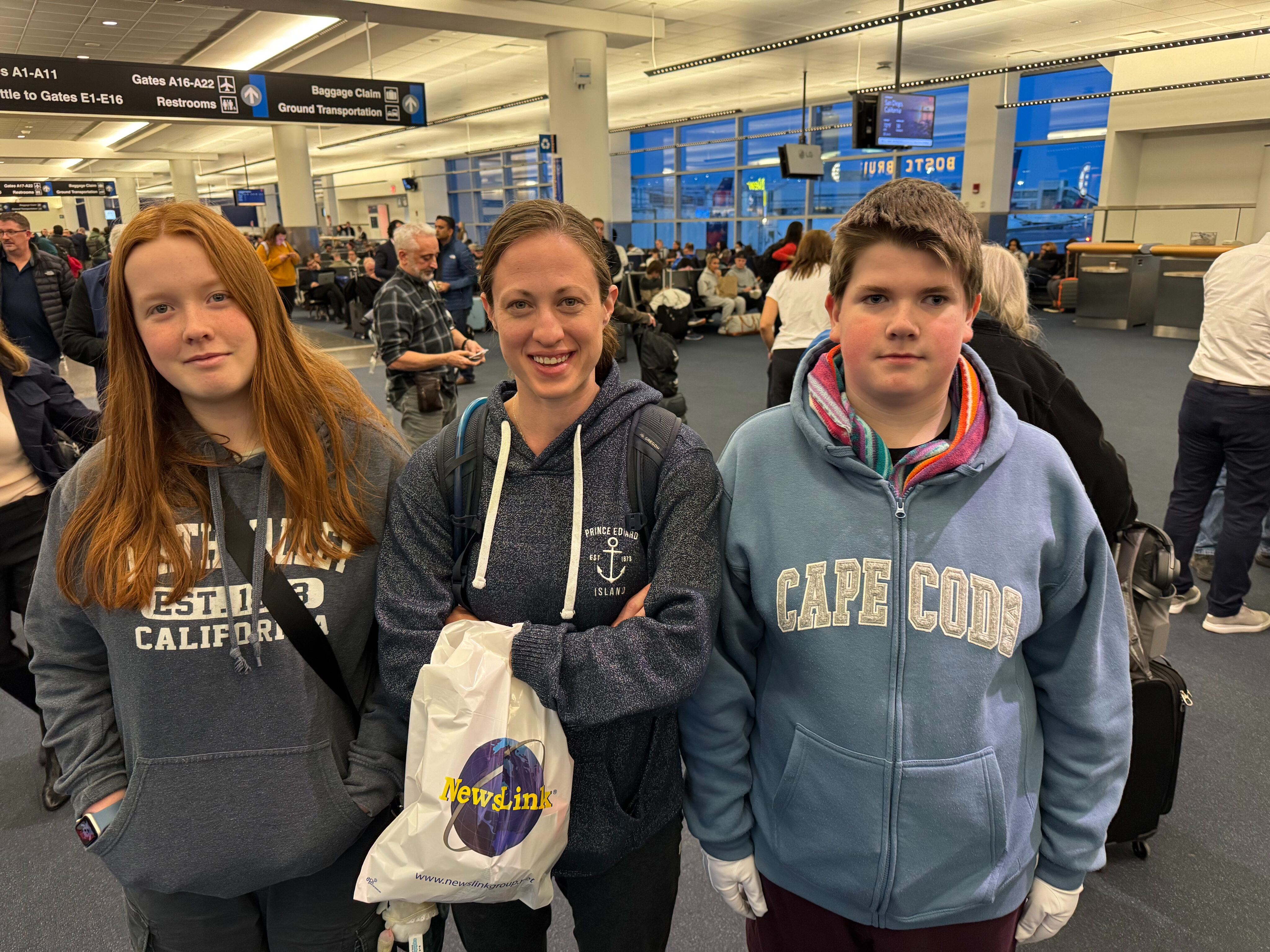 Cameron, Veronica, and Collin pose for a photo in the Delta Terminal in Boston.