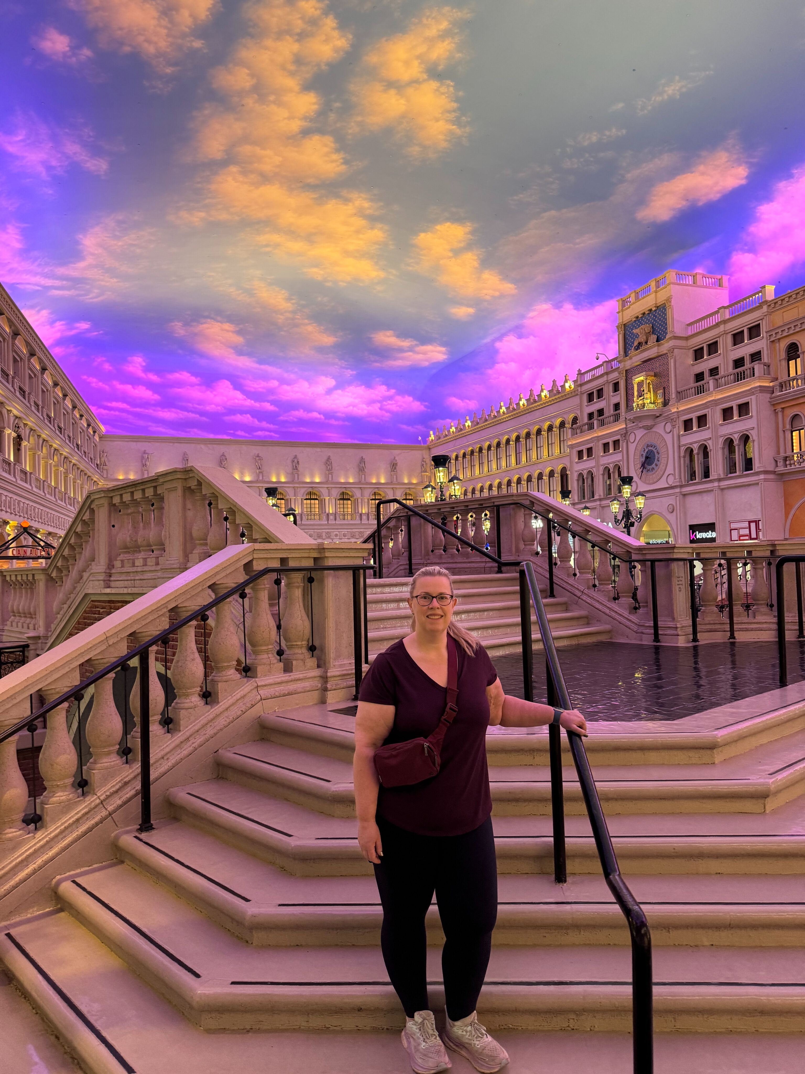 Cat standing on the Stairs at the massive food court at The Venetian with the indoor fake sky above her.