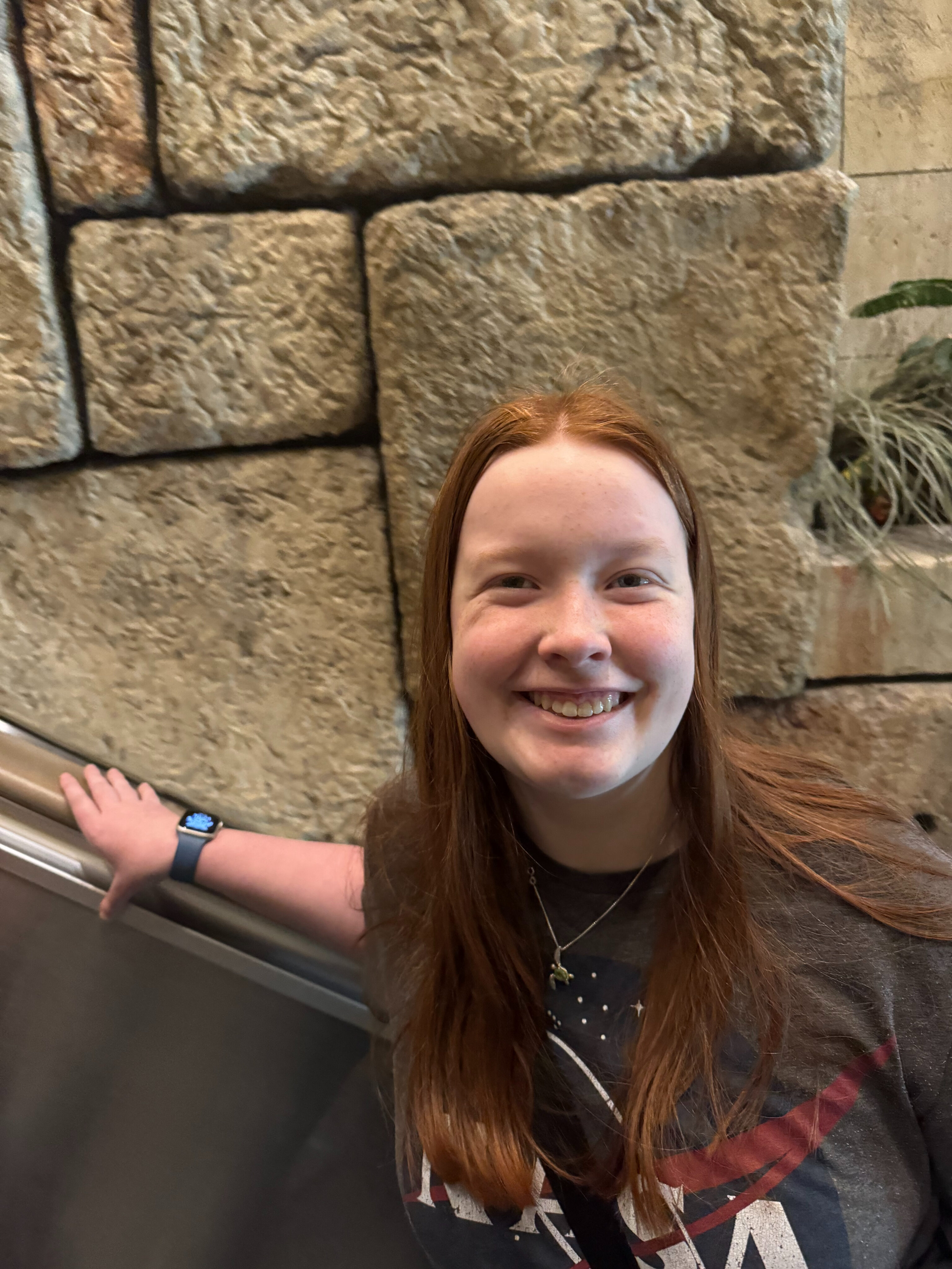 Cami on the escalator with a big smile on her way up to the Shark Reef Aquarium.