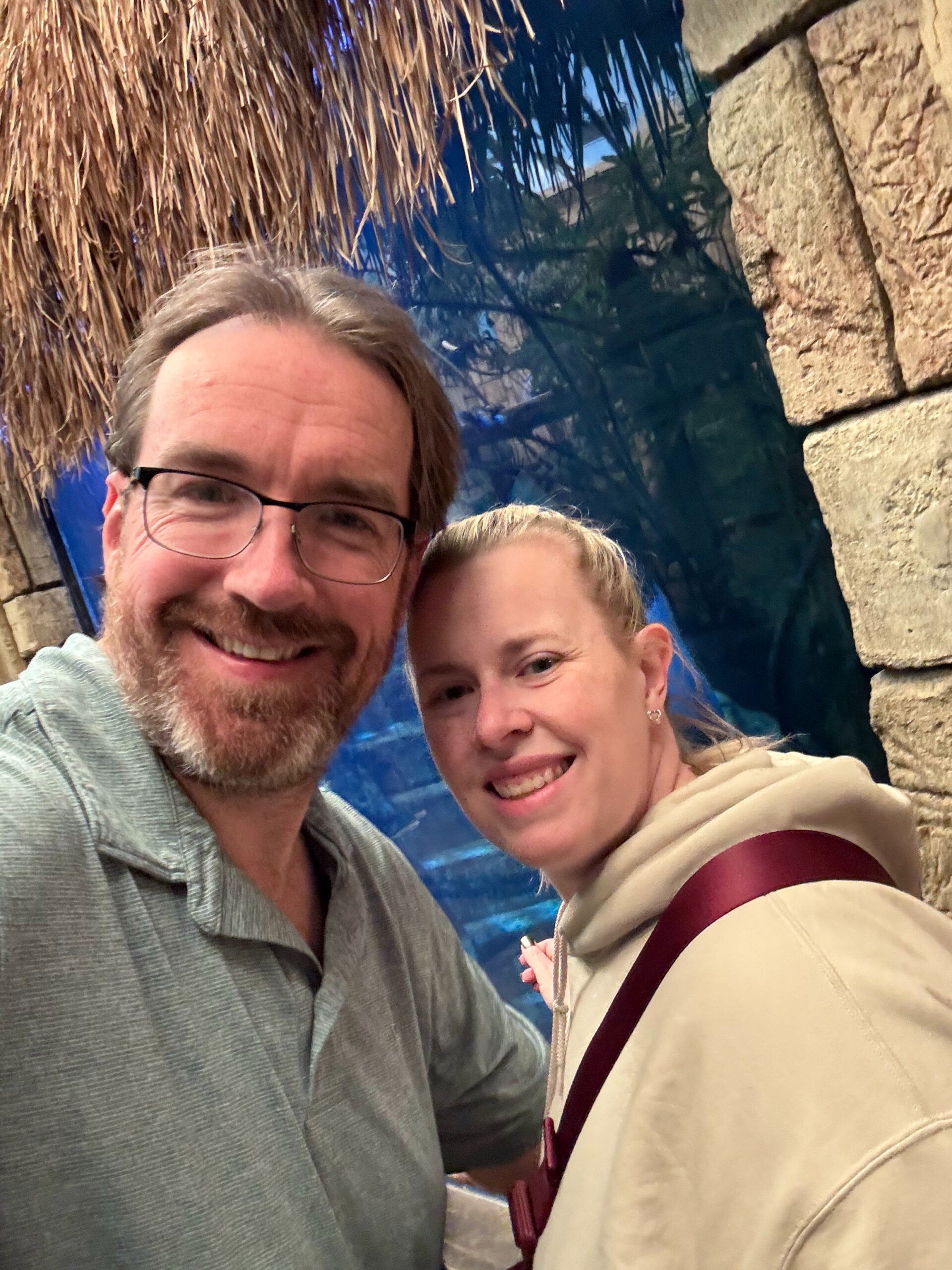 Chris and Cat smiling in front of a fish tank in the Shark Reef Aquarium.