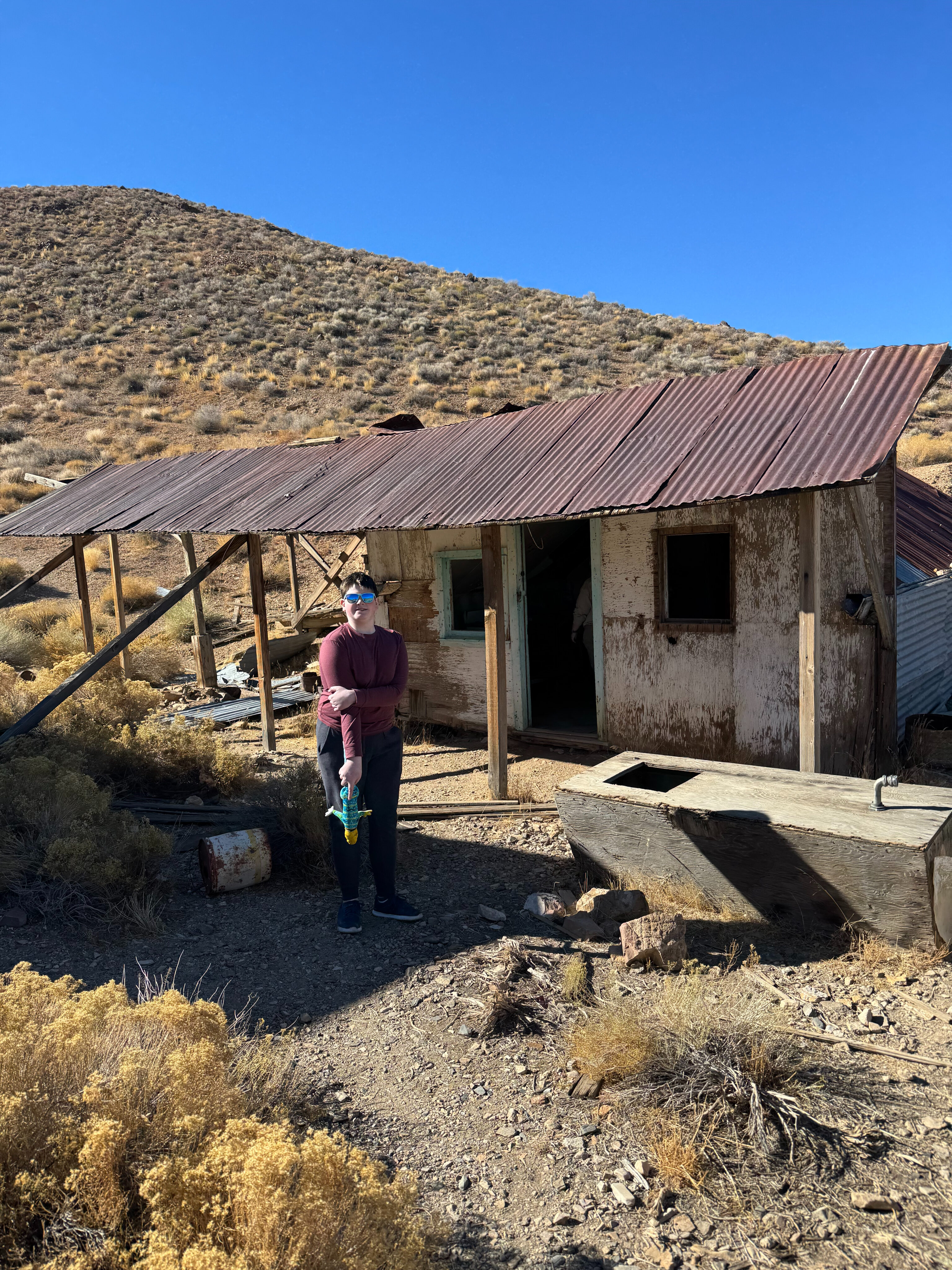 Collin standing around the old building in Harrisburg ghost town in Death Valley.