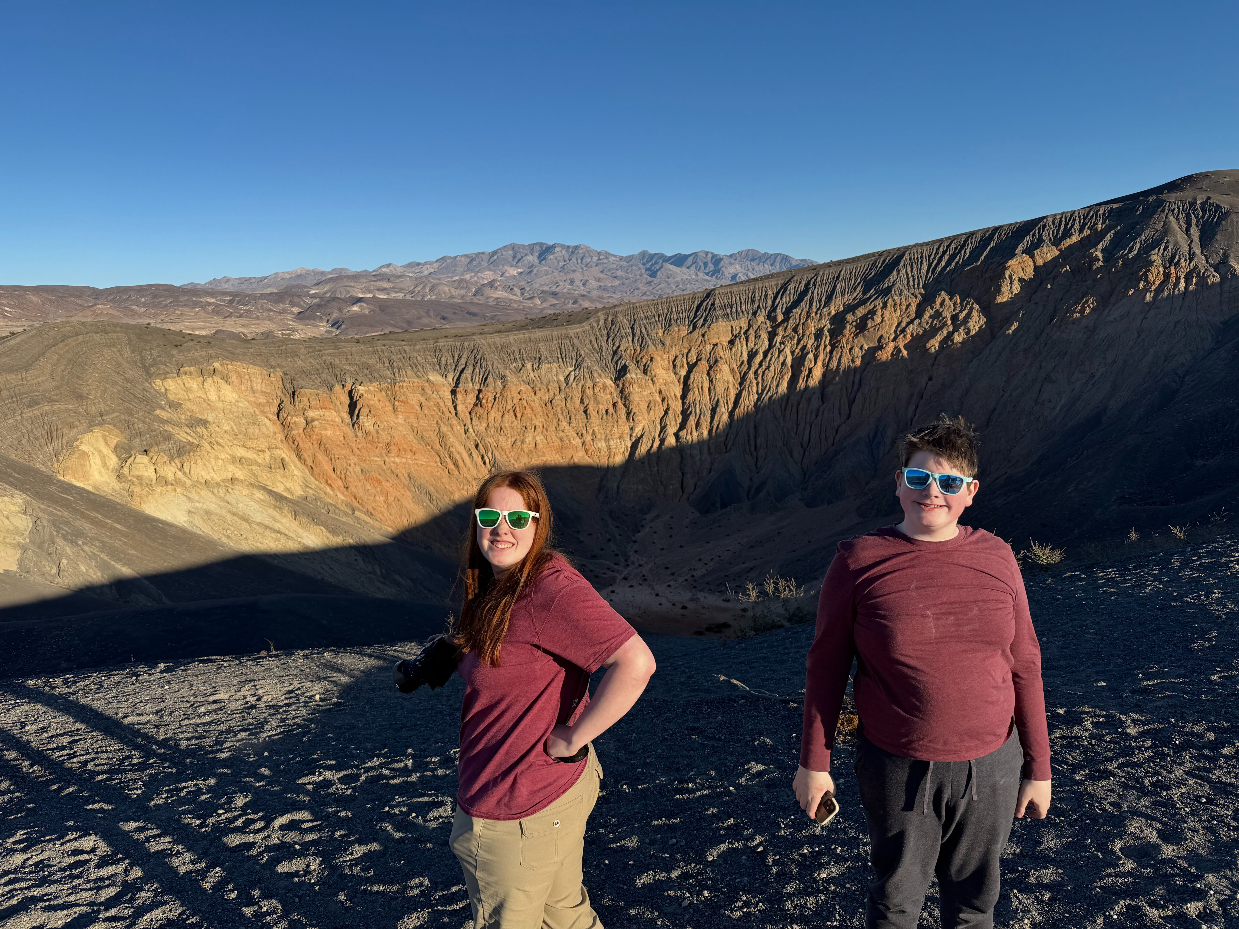 Cameron and Collin standing on the edge of the Ubehebe Crater in Death valley. Both wearing sunglasses. 