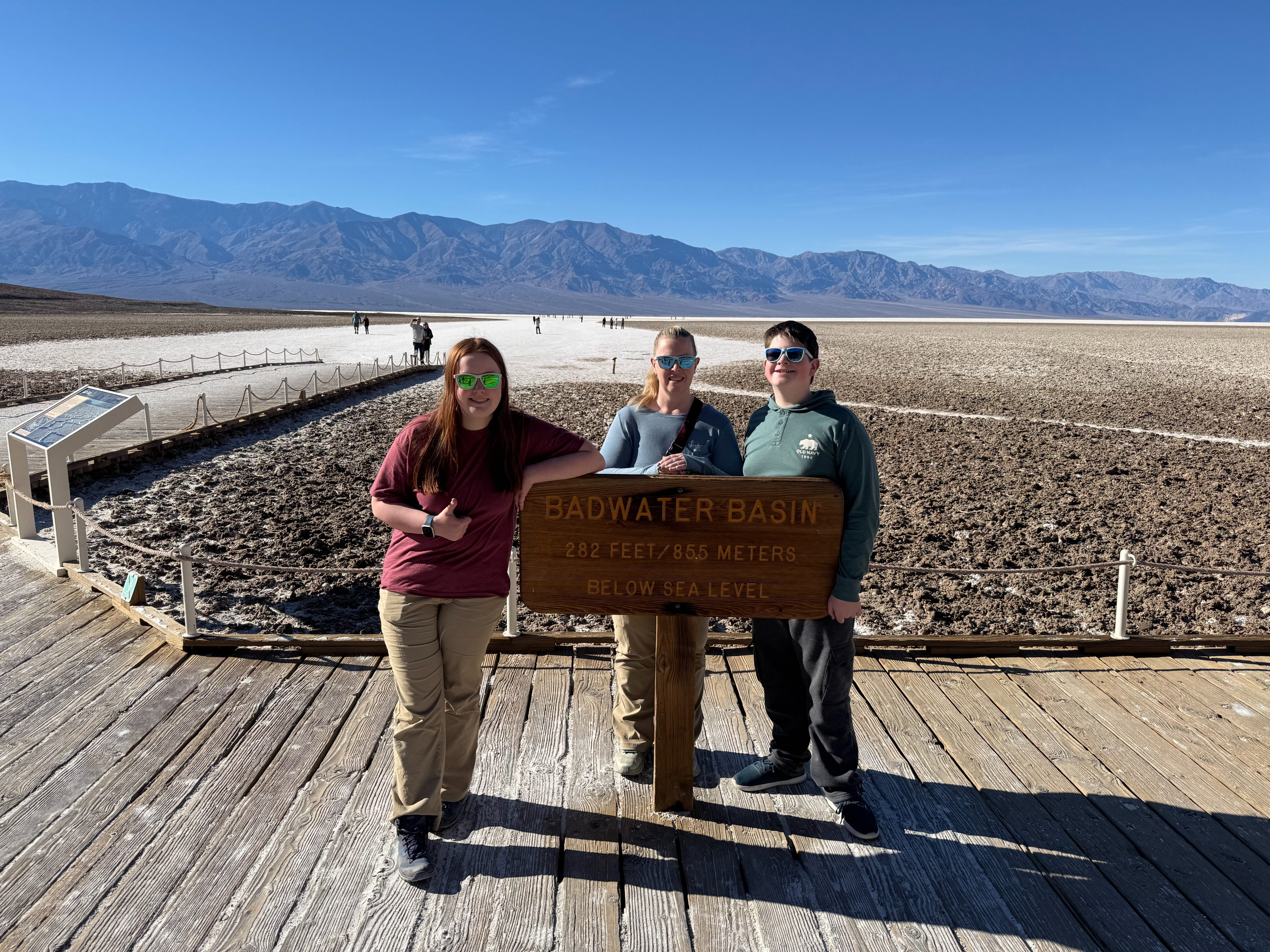 Cat, Cameron and Collin standing at the Badwater sign - the lowest point in the US. 