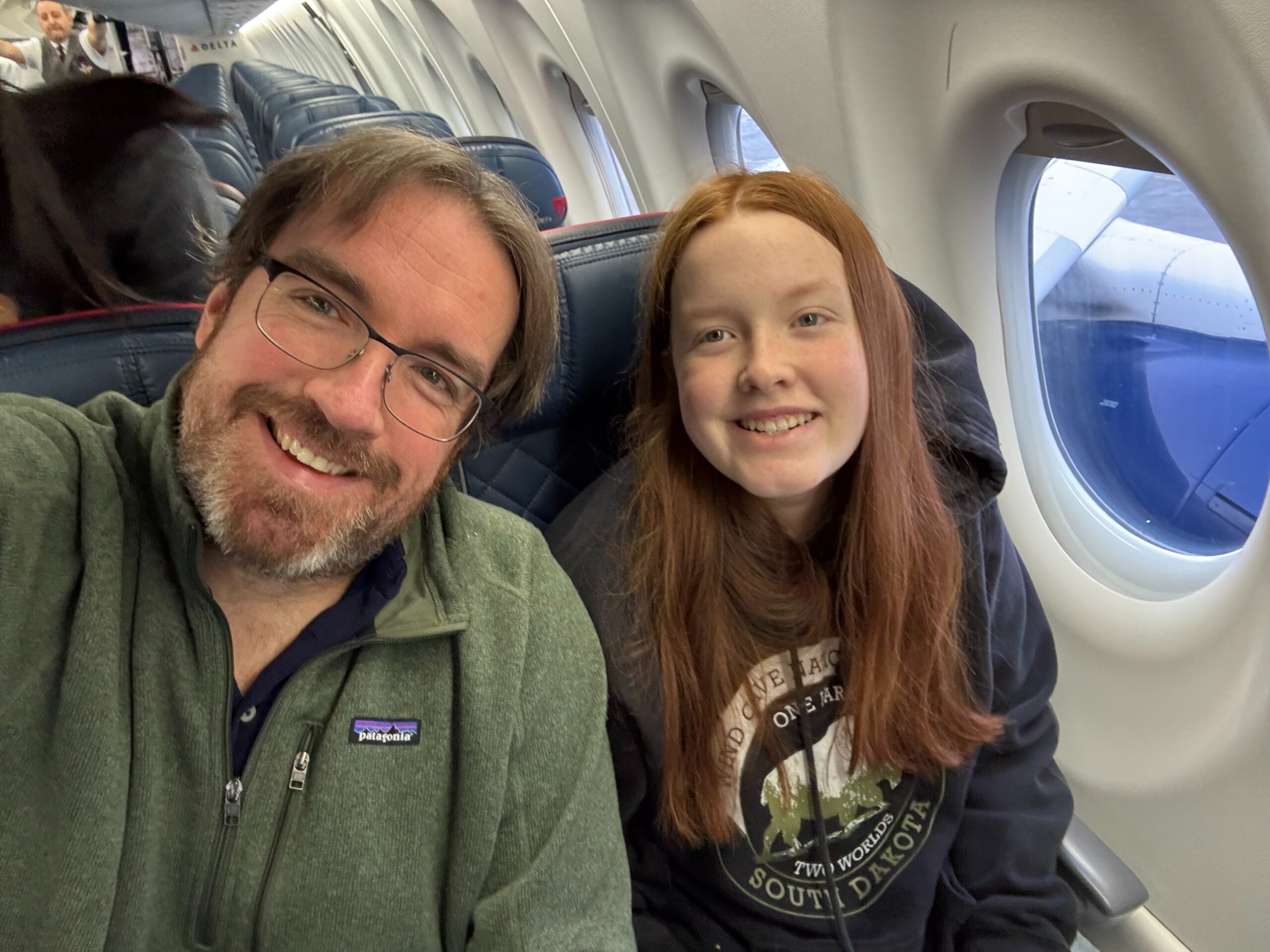 Cameron and Chris sitting on a Delta plane in Boston about to fly to Texas.