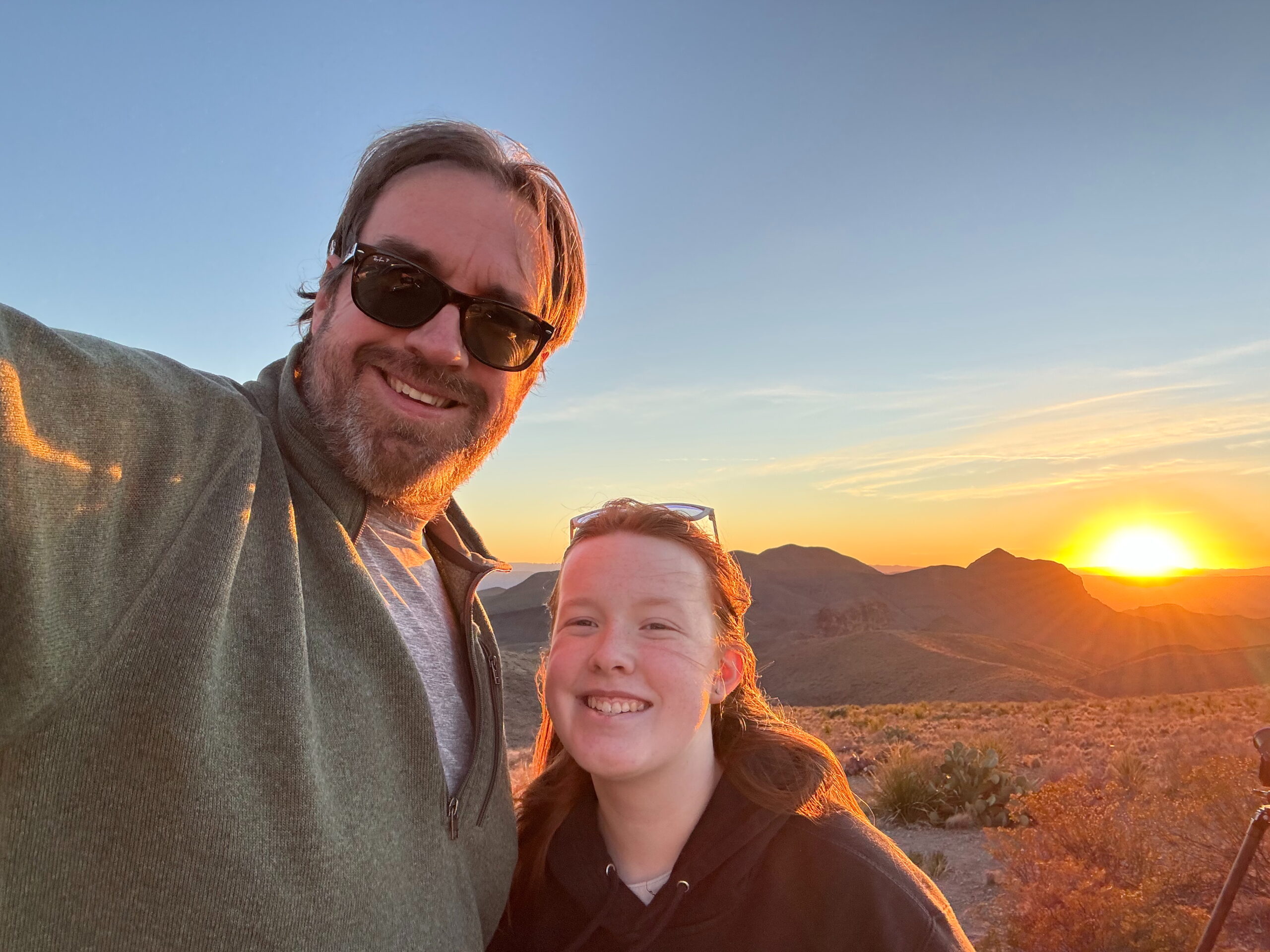 Cameron and I standing on a trial near Sotol Vista Overlook with a stunning sunset behind overlooking the desert valley.