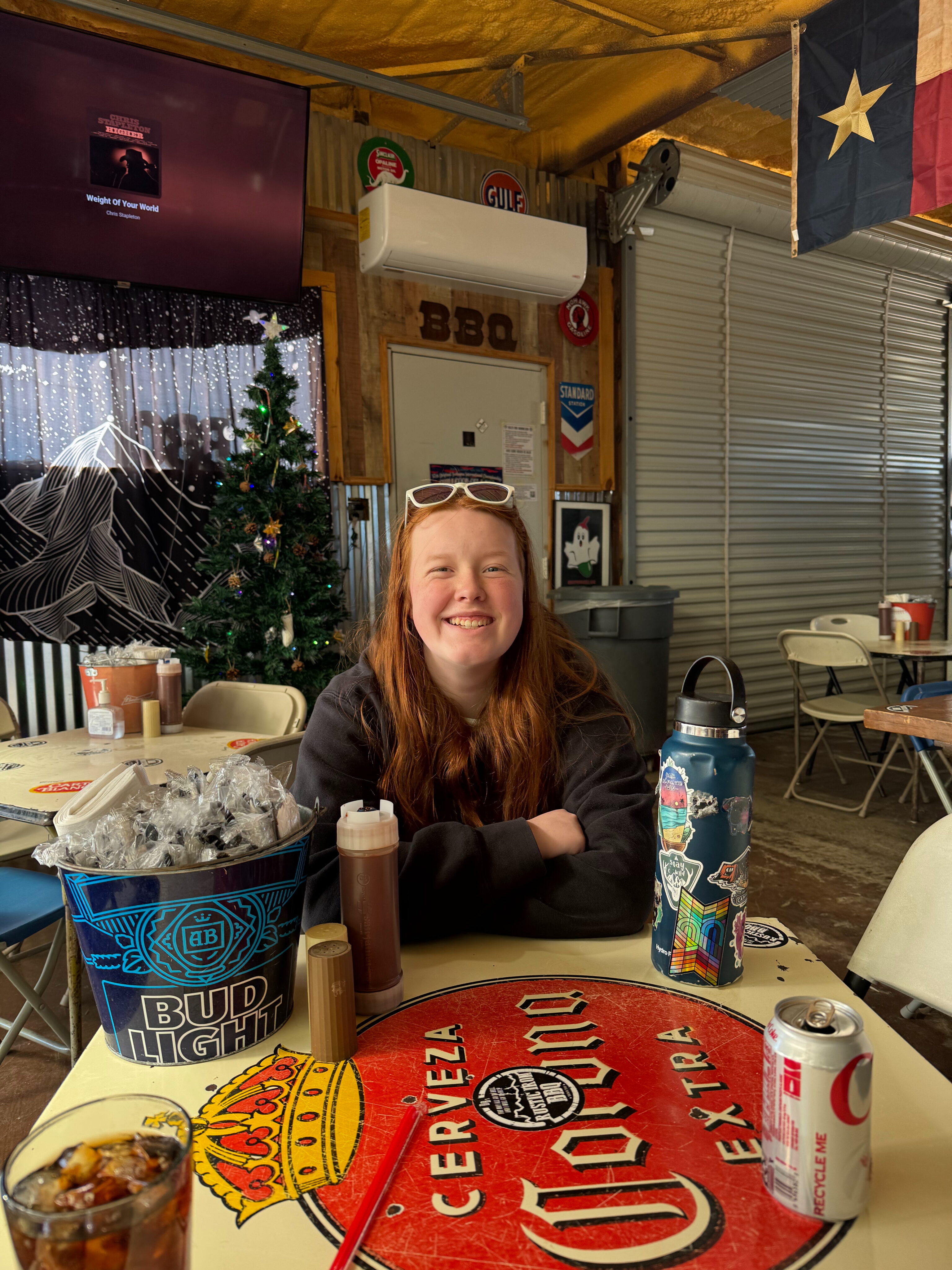 Cameron all smiles sits at a table at DB's Rustic Iron BBQ.