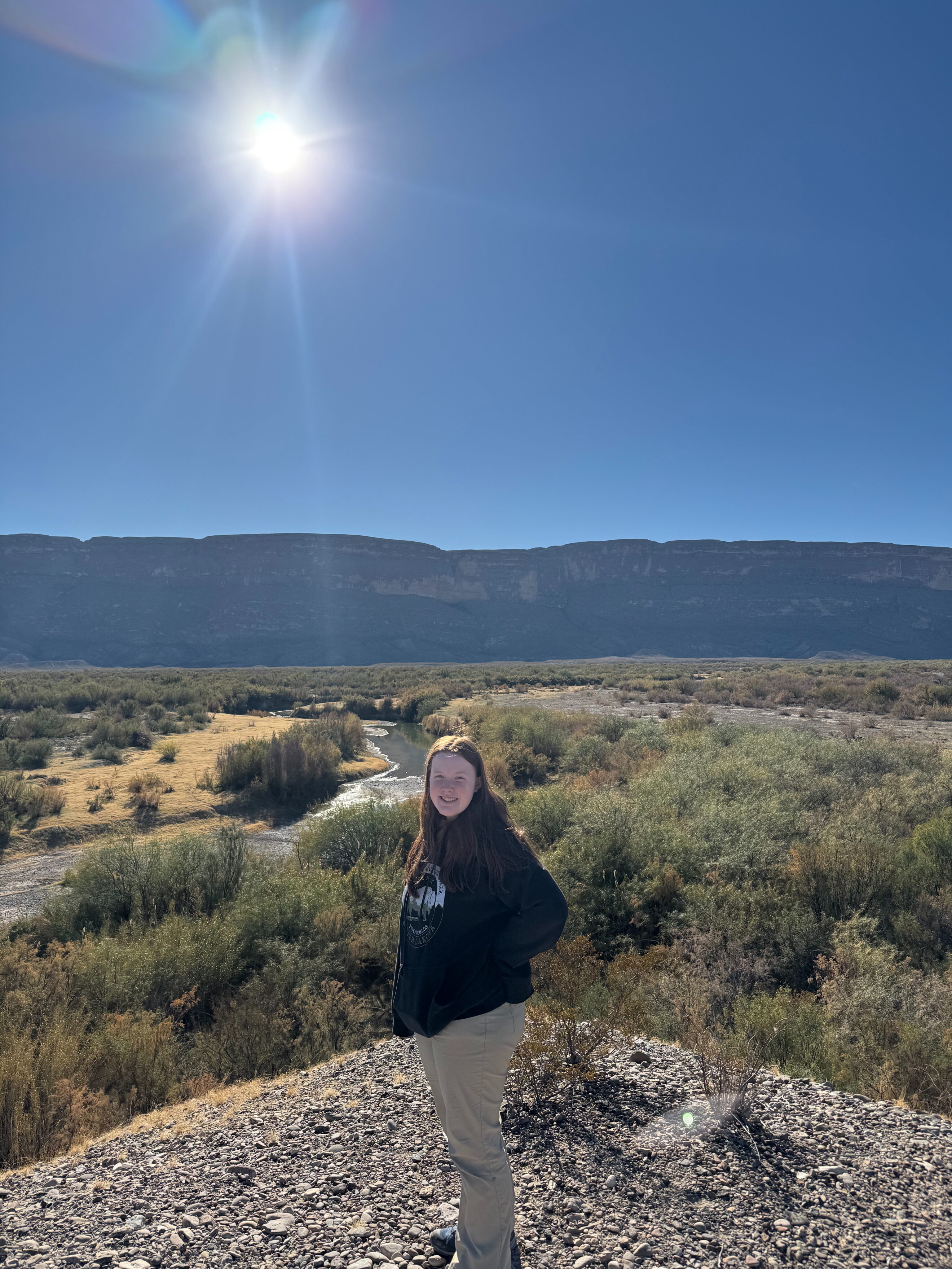 Cameron standing in on a trail in the desert overlooking the Rio Grand River in Big Bend.