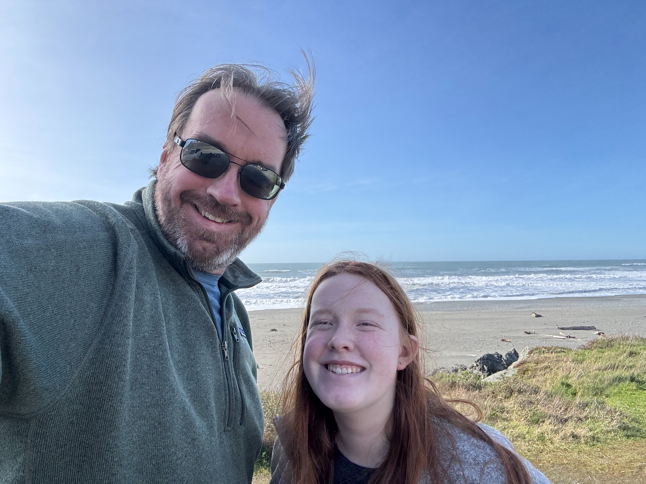 Cameron and myself with Ariya's Beach in the background and a bright blue sky above us.