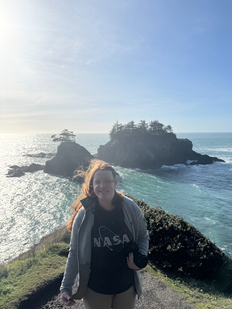 Cameron at the very edge of Thunder Cove with the Pacific Ocean behind her as well as a few small islands.