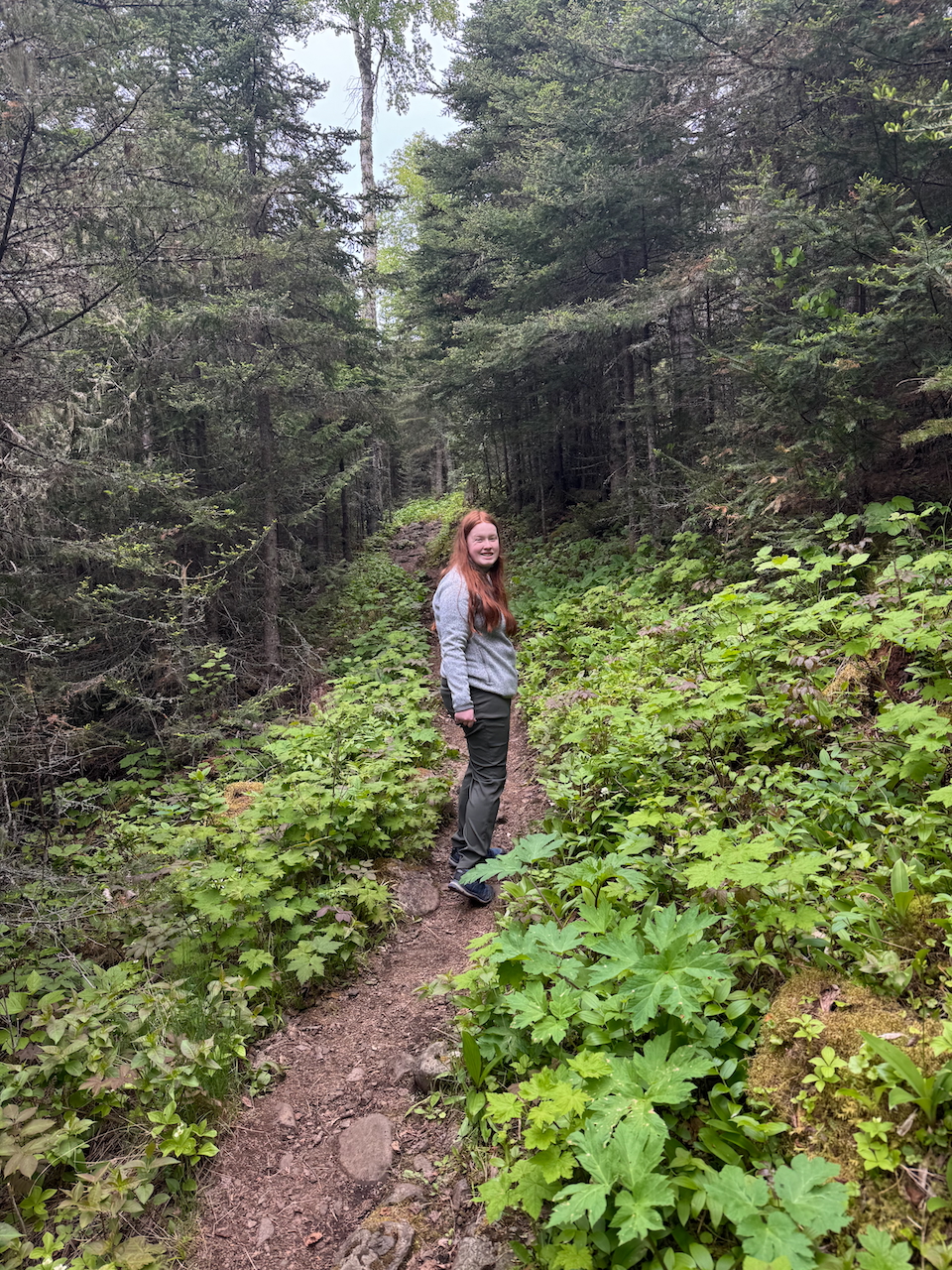 Cameron turning back to smile for a photo on a trail deep in the forest of Isle Royale.