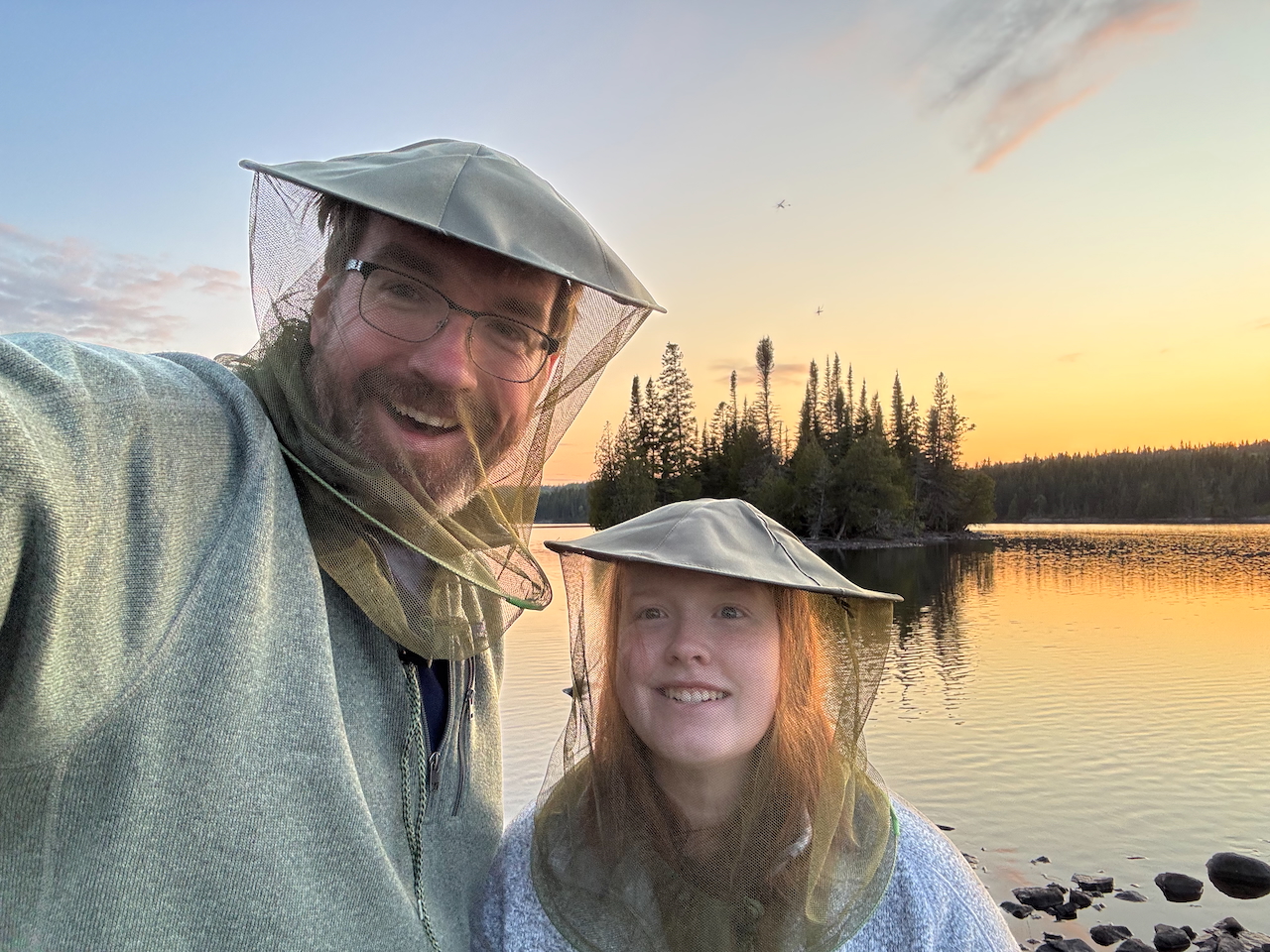 Cameron and myself pose for at Moose Point at sunset in Isle Royale - a red and yellow sky are behind us.