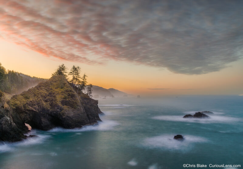 Long exposure sunrise photo from Thunder Rock Cove in Oregon, showing sea stacks, soft water, and colorful clouds over the Pacific coastline.