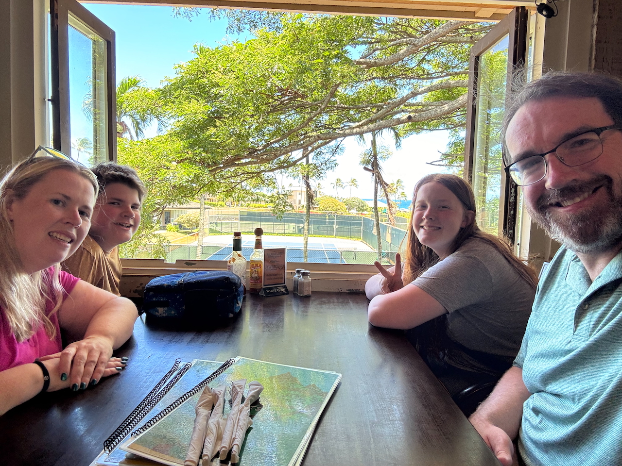 Family gathered at a restaurant table in Kauaʻi for Collin’s birthday meal.