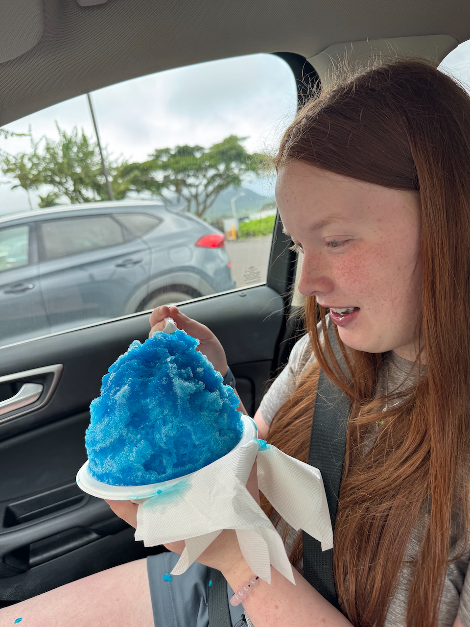 ameron enjoying blue shaved ice while sitting in the car.