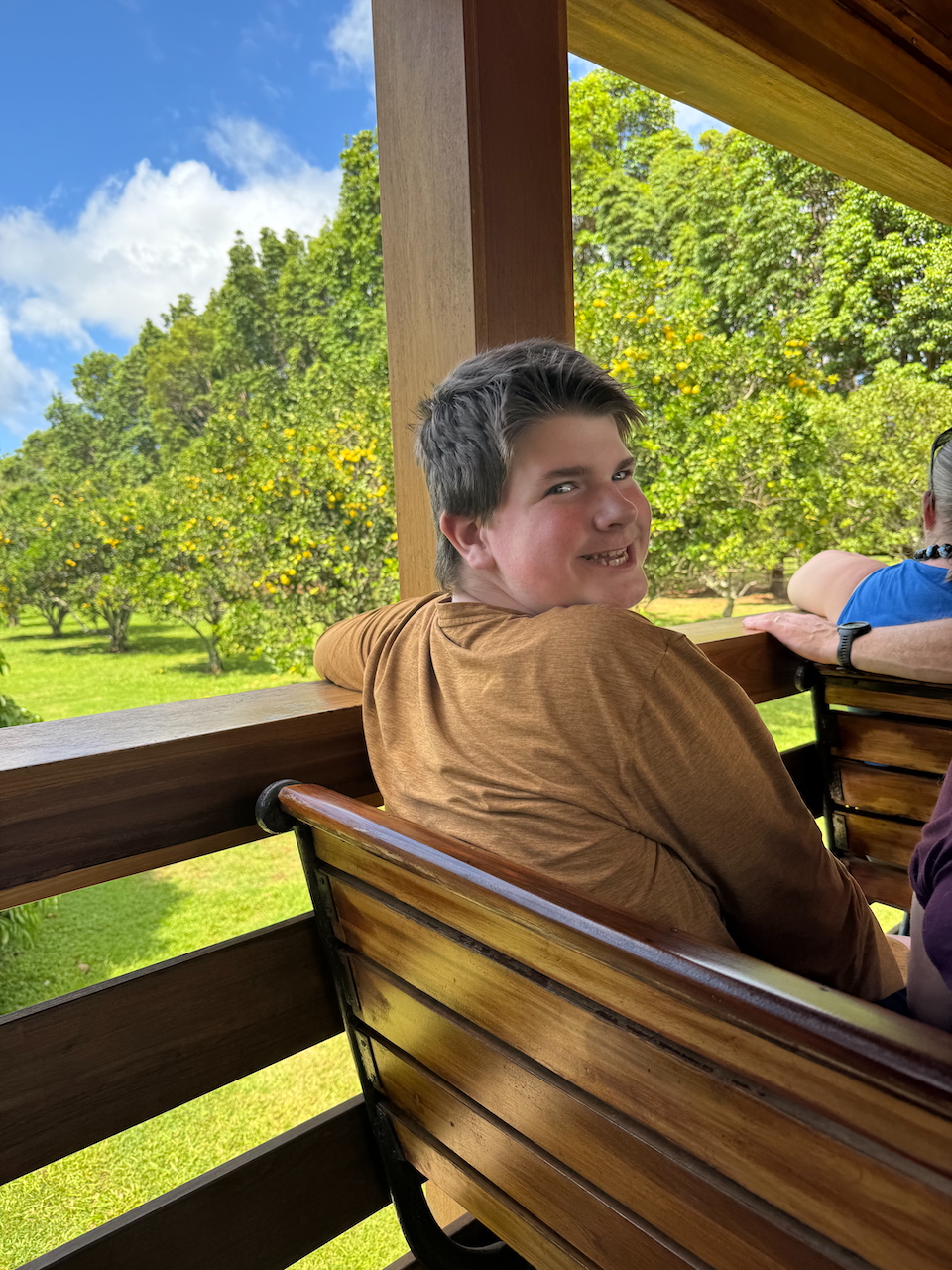 Collin seated on the Kauaʻi Plantation Railway train with fields in the background.