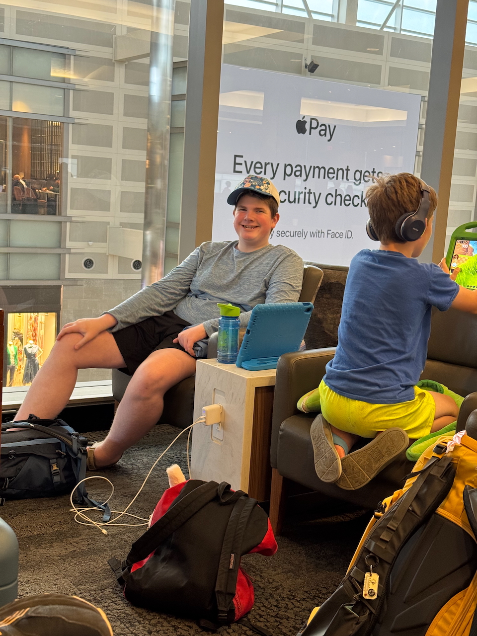 Collin and Nate sitting in Delta Sky Club lounge before their flight.