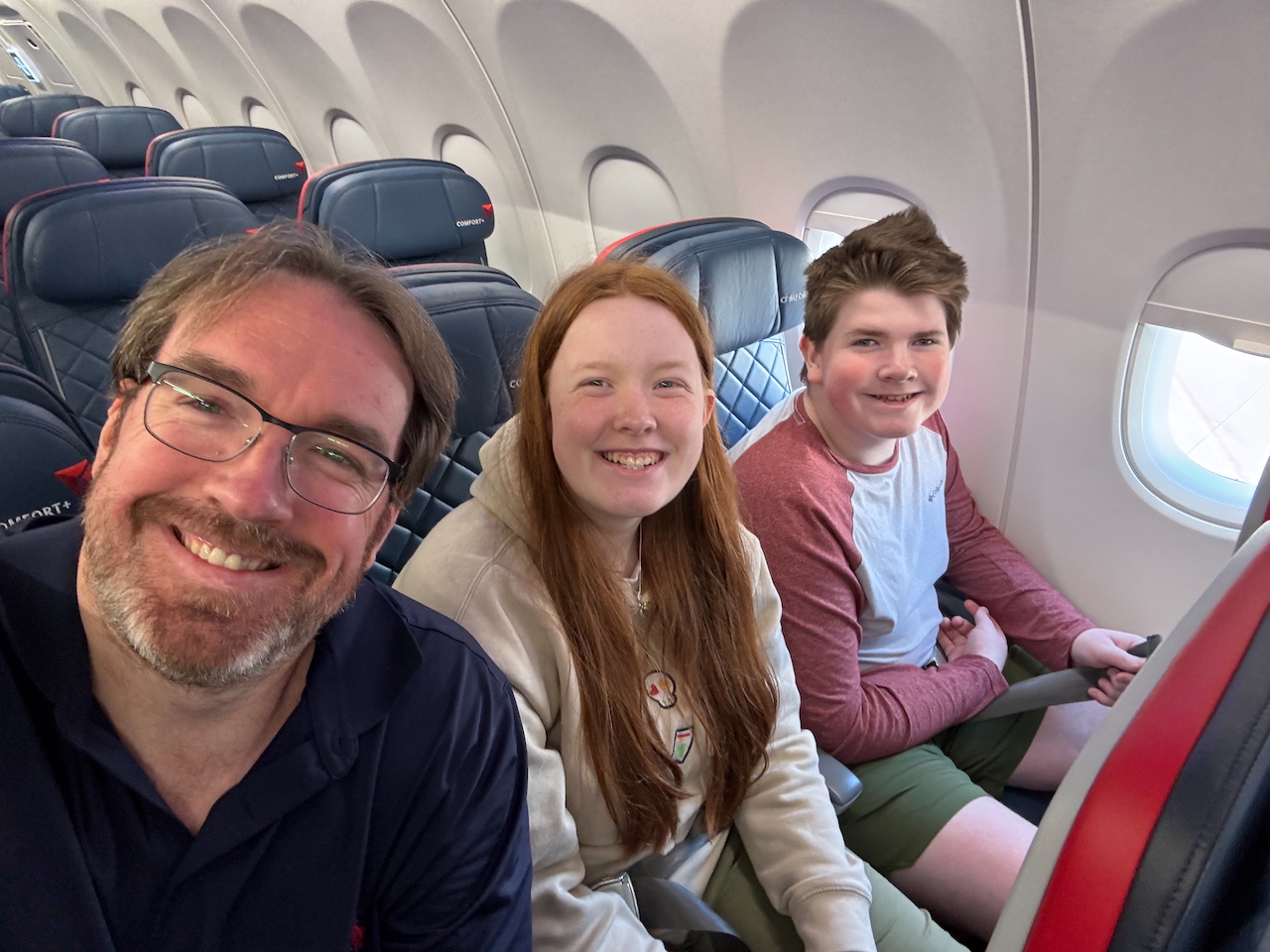 Family seated on plane before takeoff.