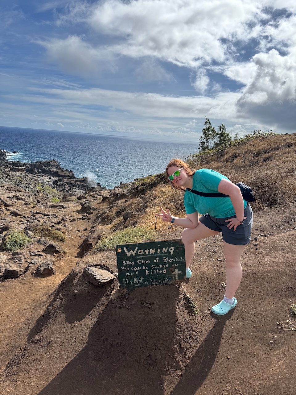 Cameron at blowhole trail sign.