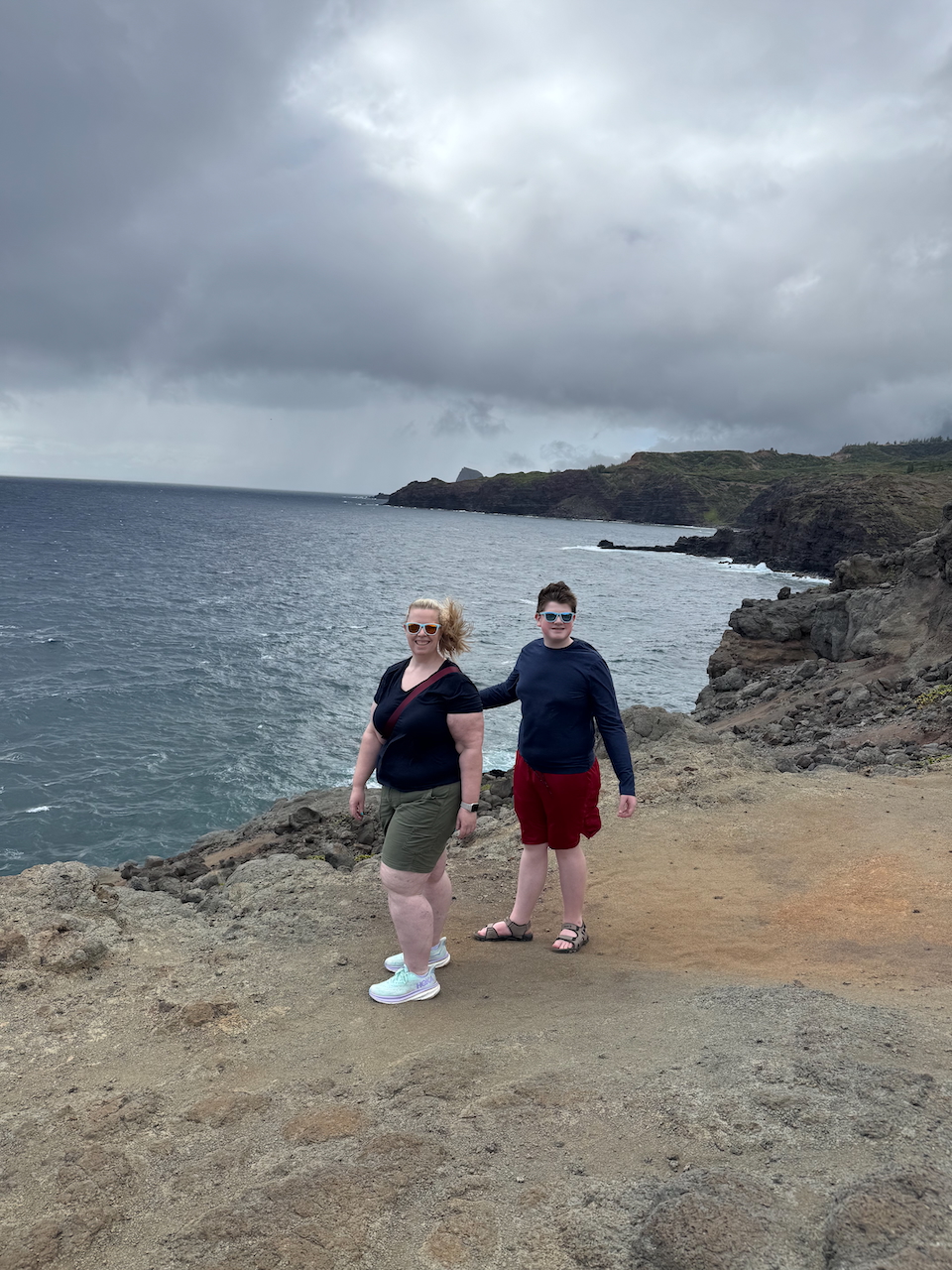 Cat and Collin walking on the cliffs on a windy day in Maui