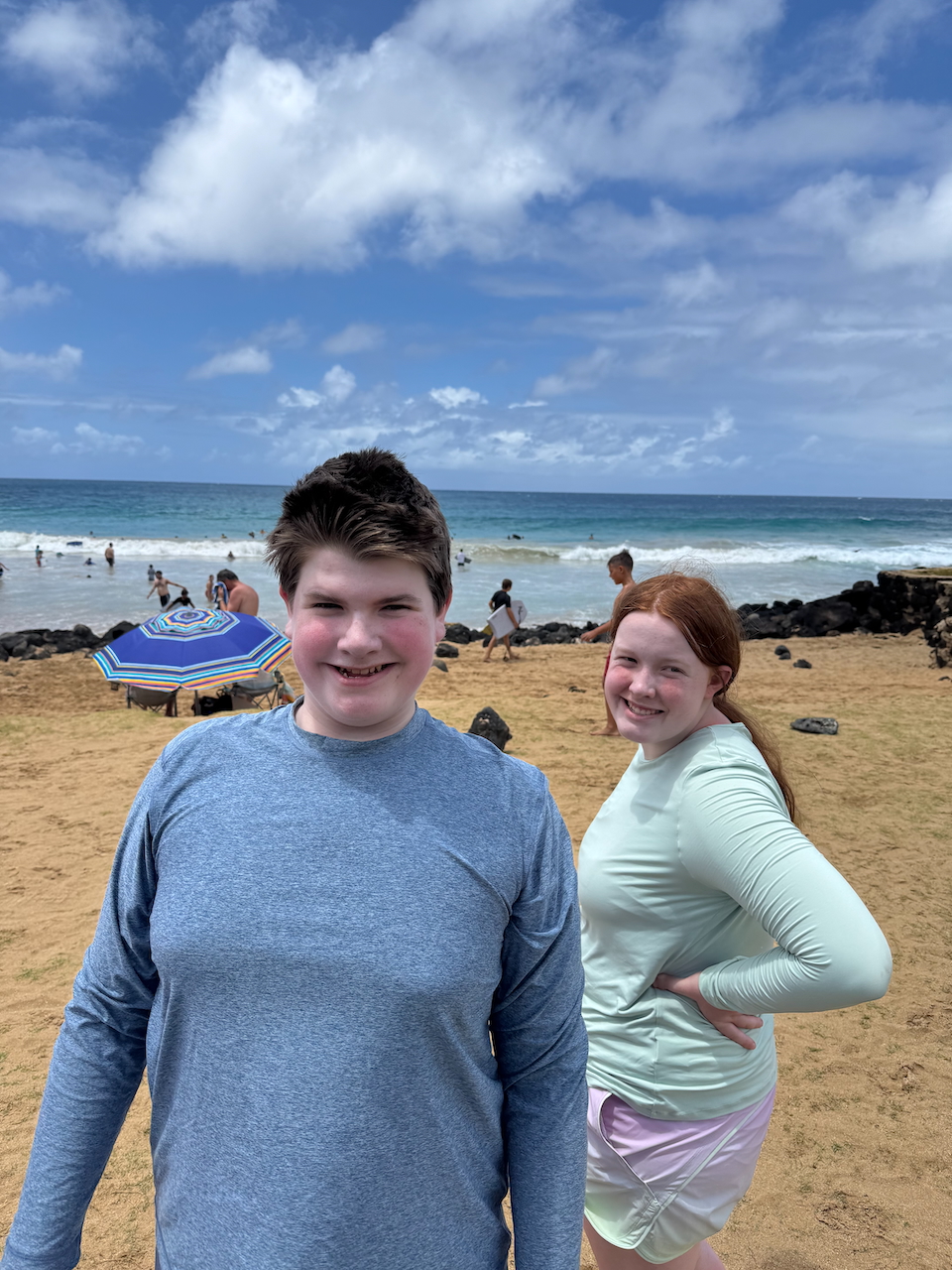 Collin and Cameron smiling at Poʻipū Beach near their Airbnb in Kauaʻi.