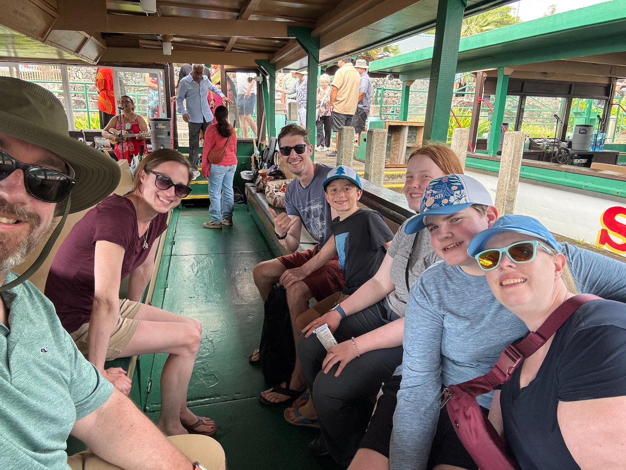 Family seated on a boat during the Kauaʻi river tour.