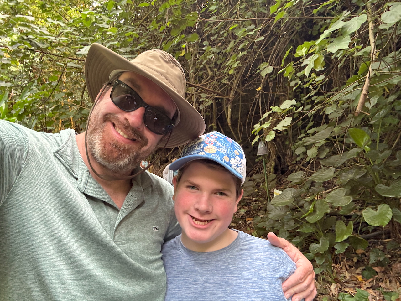 Chris and Collin smiling together on the Kauaʻi river boat.