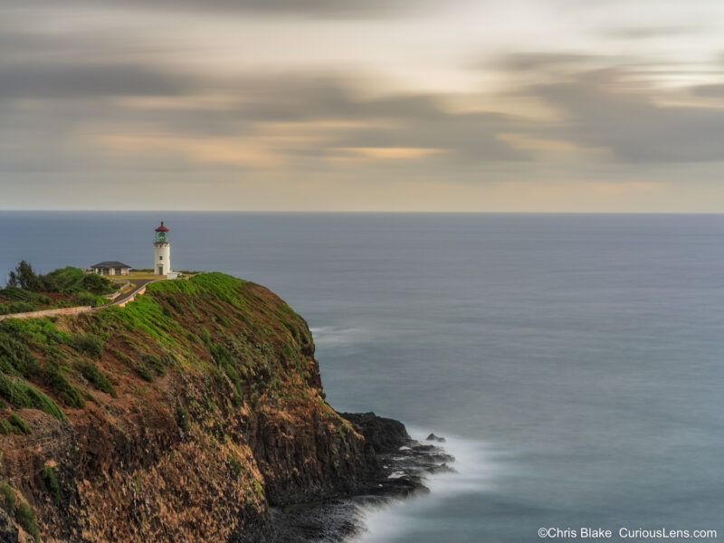 Early blue hour view of Kilauea Lighthouse on Kauai with long exposure movement in the sky and water before sunrise.