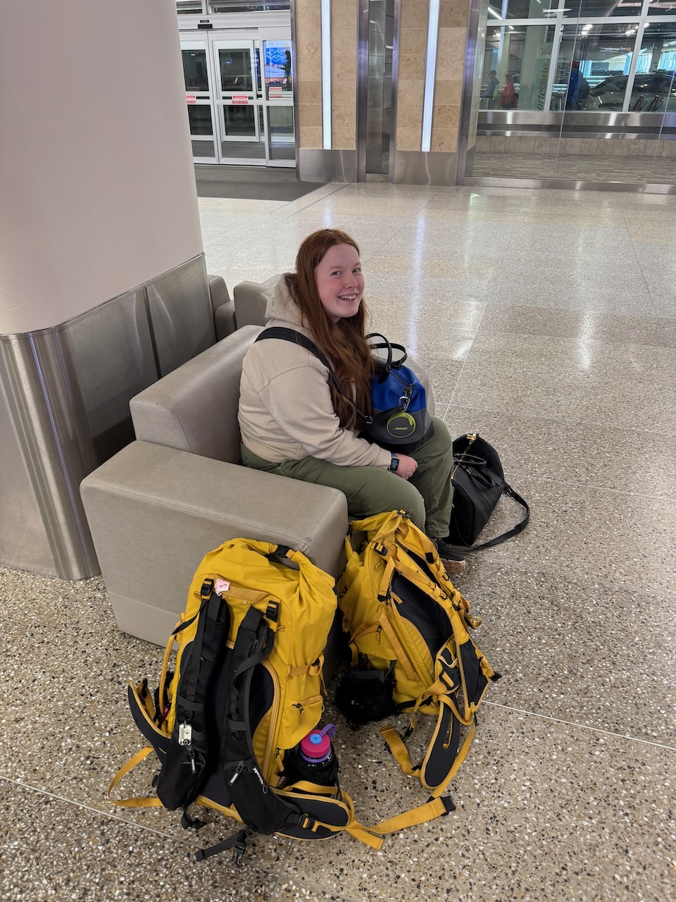Cameron sitting on the floor at Minneapolis–St. Paul International Airport waiting for our bags after landing.