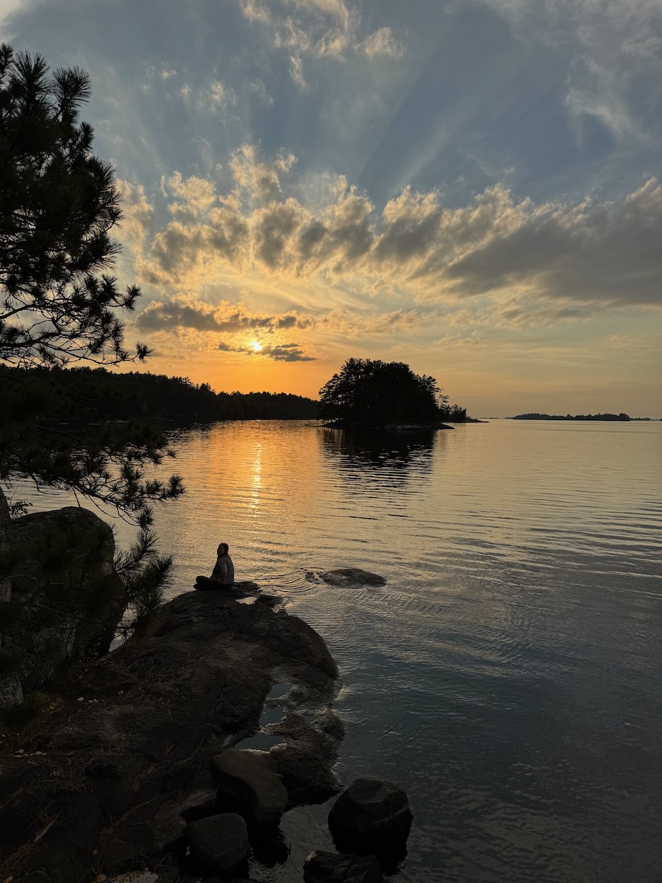 Cameron standing on the rocks above the lake at the Ash River area in Voyageurs National Park during sunset.