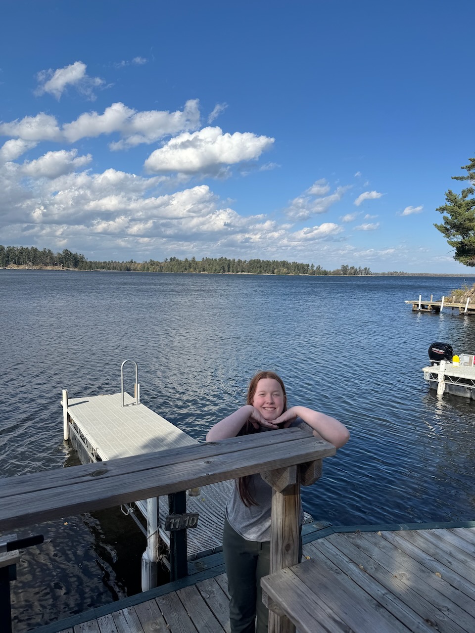 Cameron leaning on the railing of the dock at Northern Lights Resort on Lake Kabetogama.