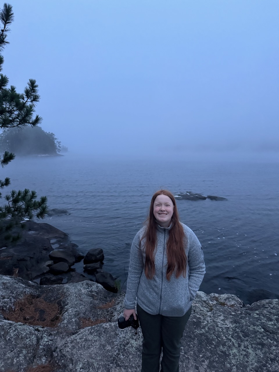 Cameron standing by the fog-covered shoreline at Ash River in Voyageurs National Park after a storm.
