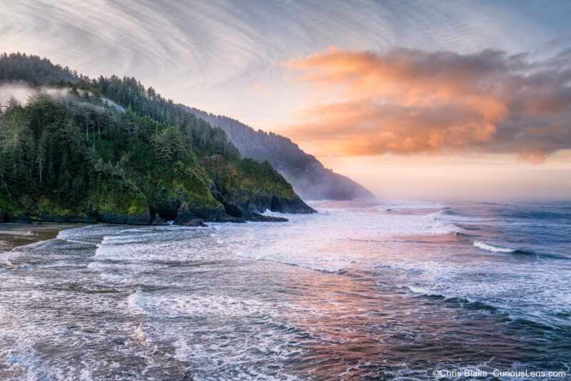 Heceta Head Lighthouse coastline at dawn with colorful clouds, waves, and sea spray