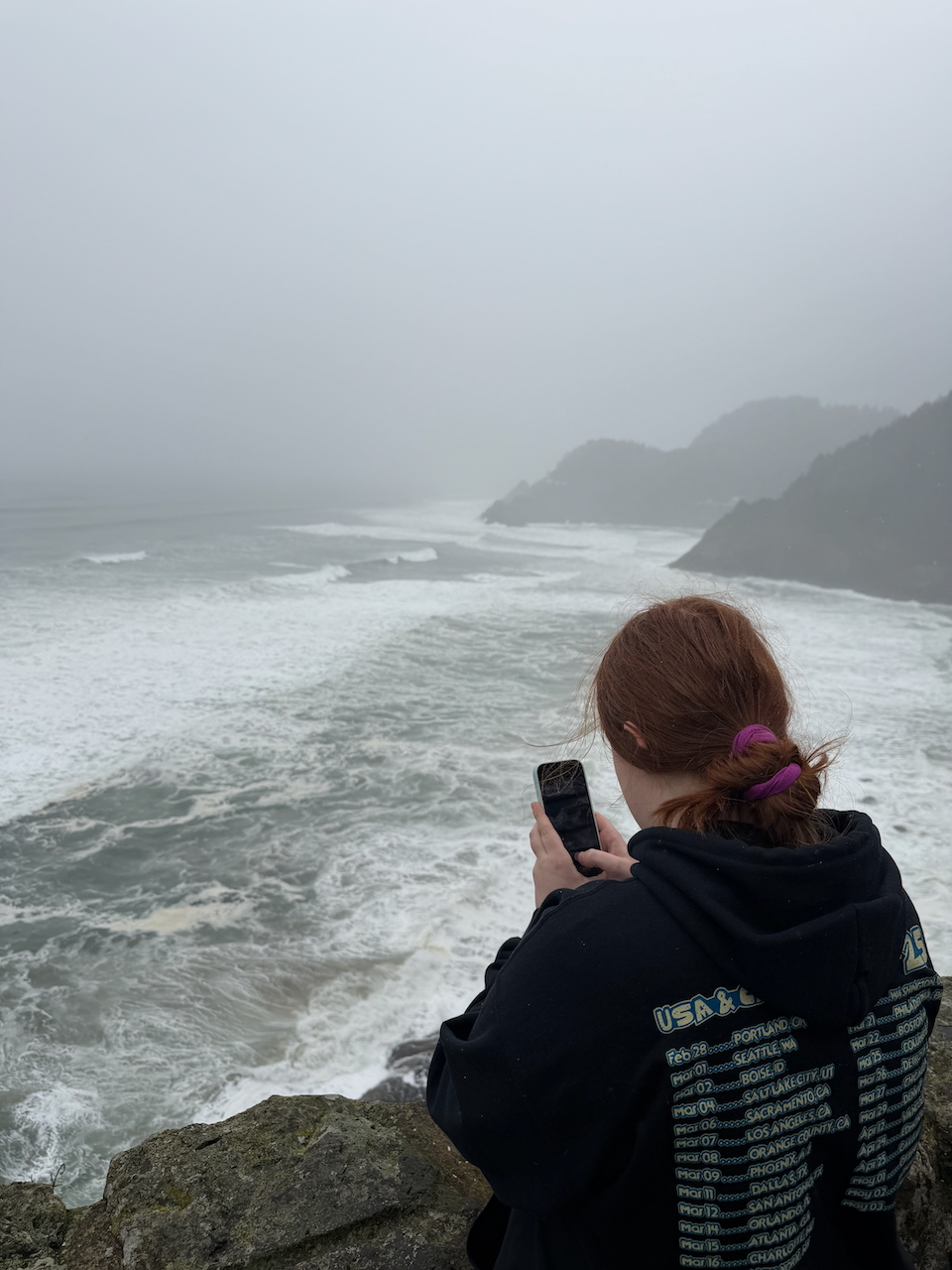 Cameron photographing the Oregon Coast from a Highway 101 overlook during a coastal storm