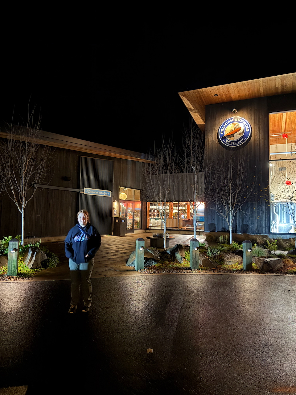 Cameron standing outside Pelican Brewing at night on the Oregon Coast