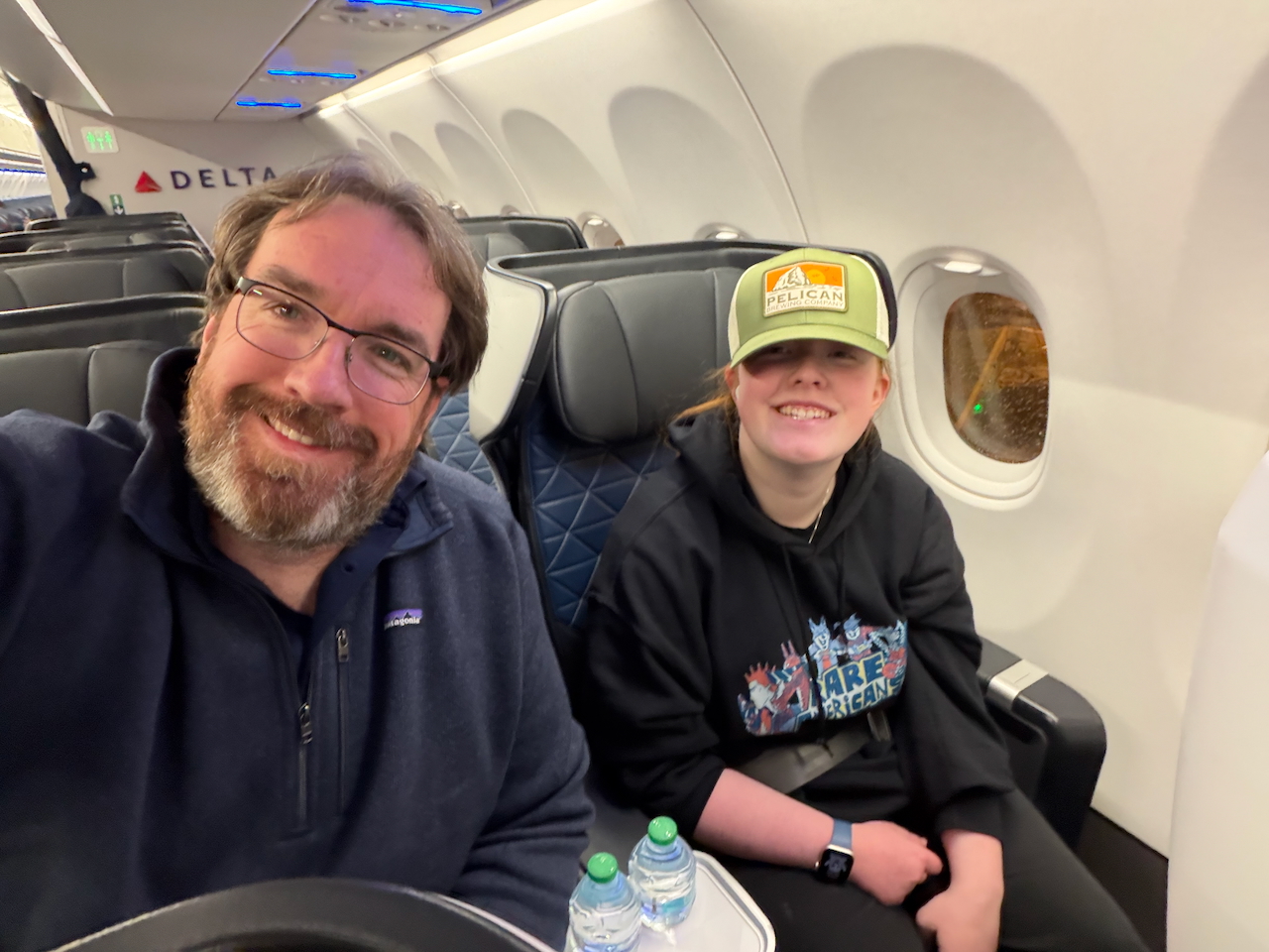 Chris and Cameron seated on a Delta red-eye flight returning to Boston