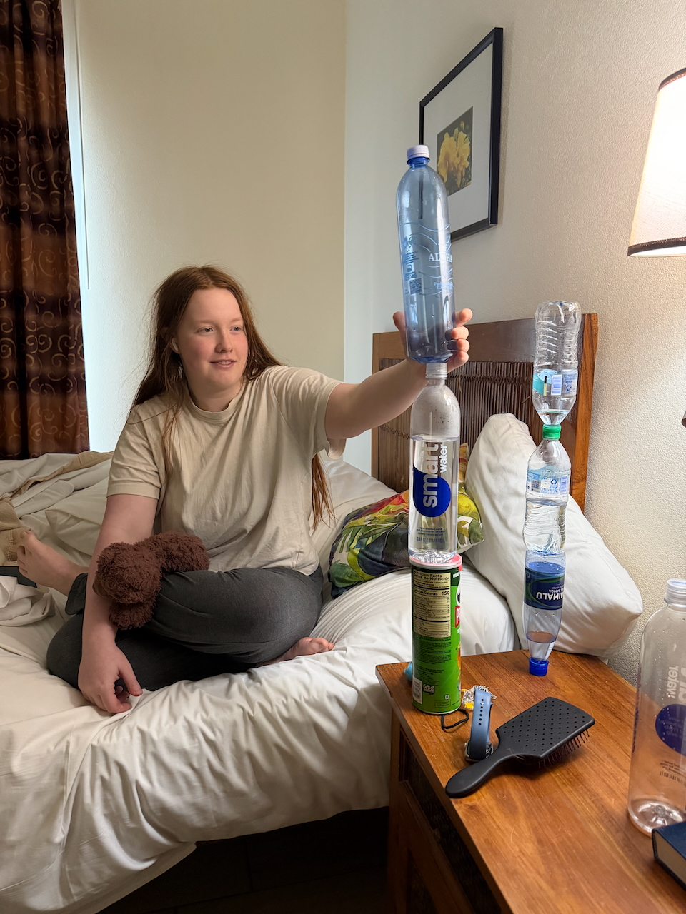 Cameron stacking water bottles in the hotel room.