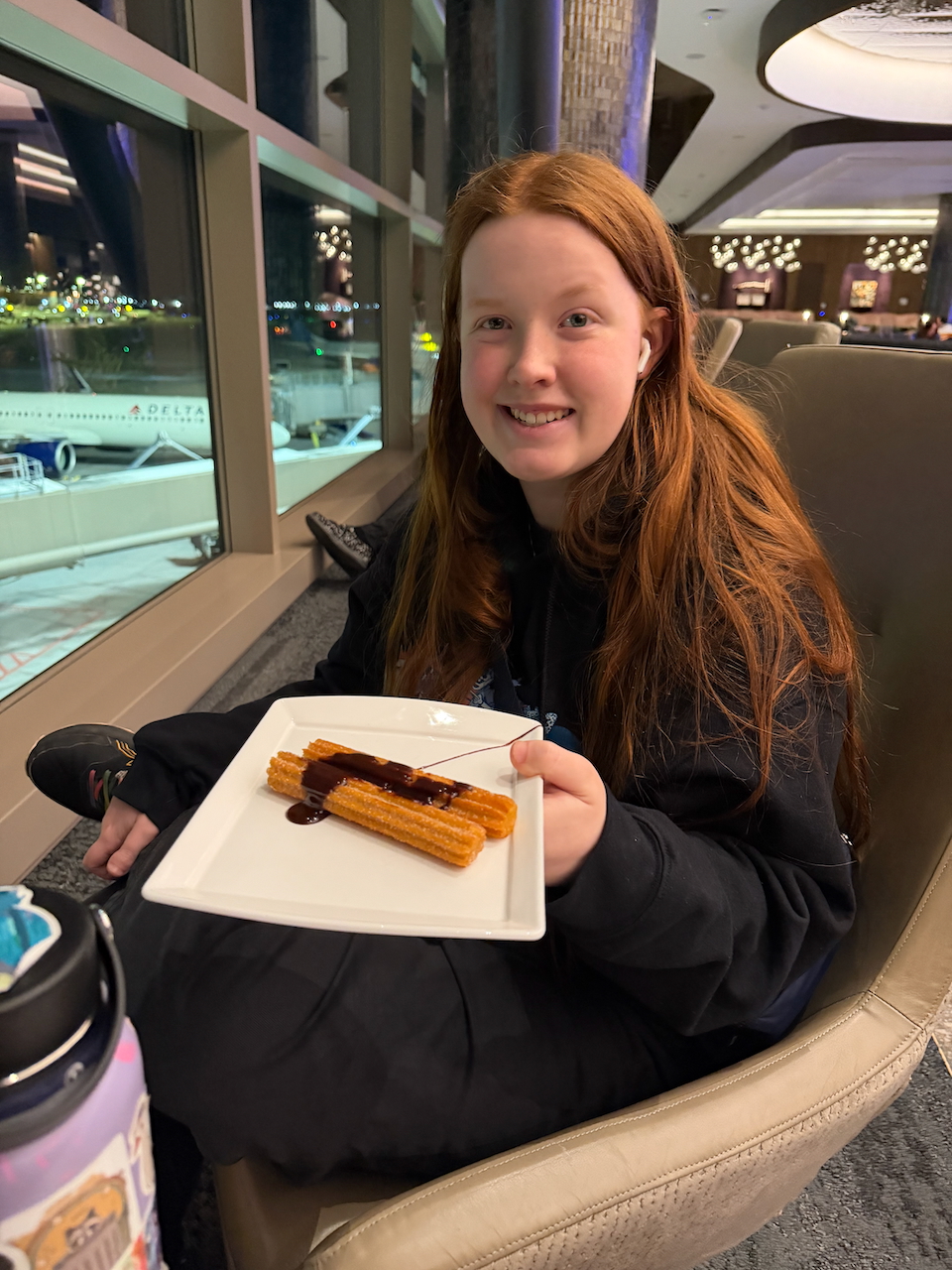 Cameron eating churros in the Delta Sky Club.