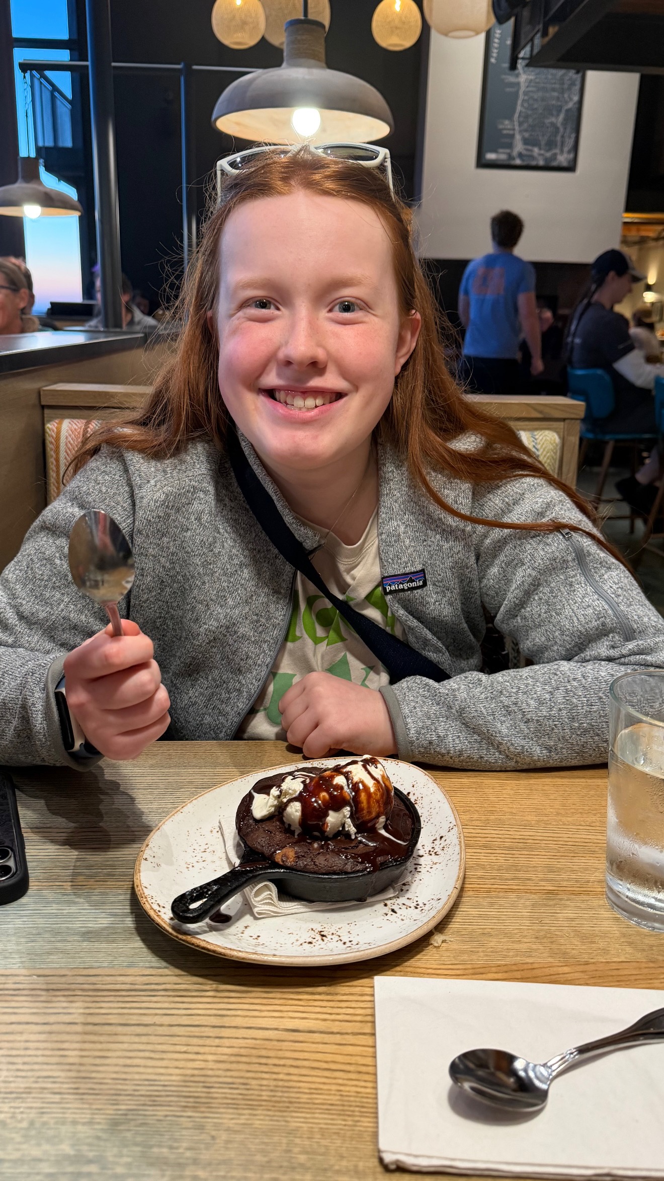 Cami smiling with dessert at Pelican Brewing on the Oregon Coast.
