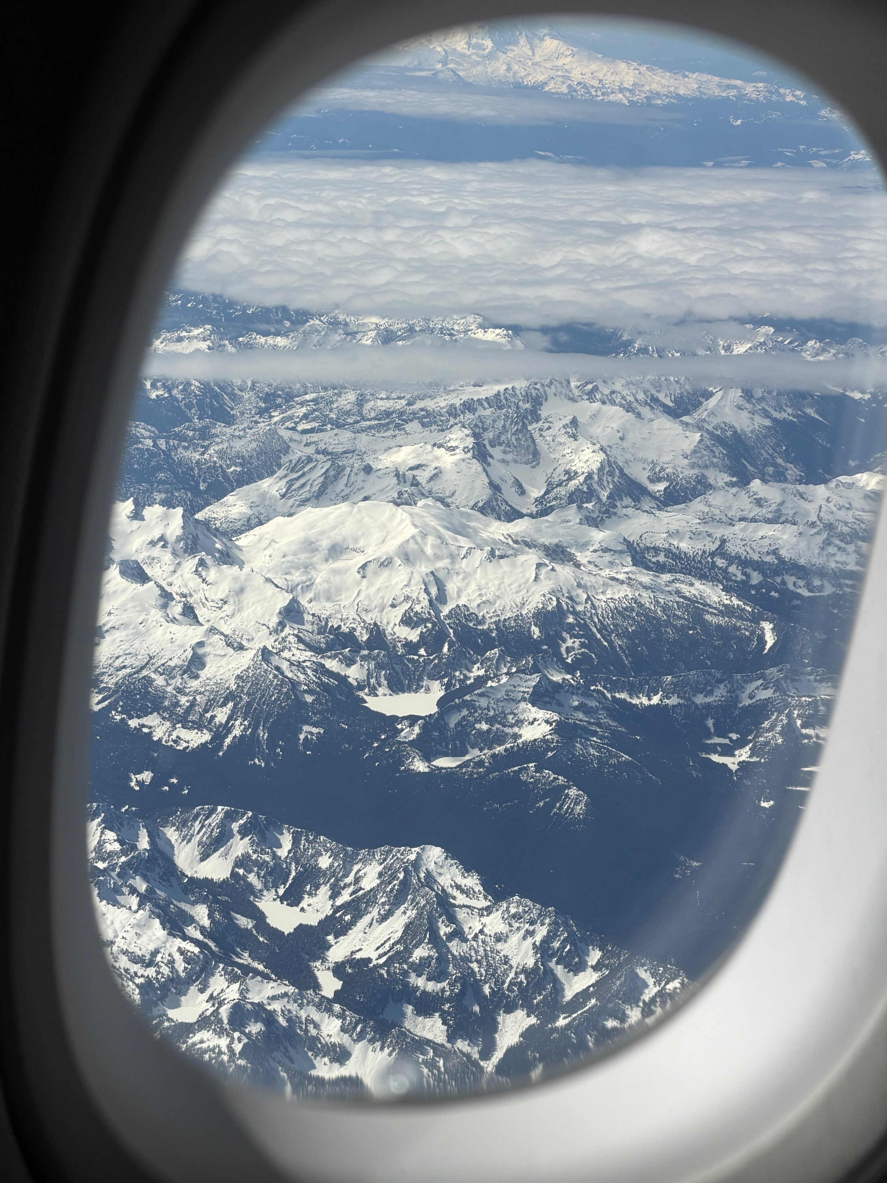 Snow-covered peaks of the North Cascades seen from an airplane window.