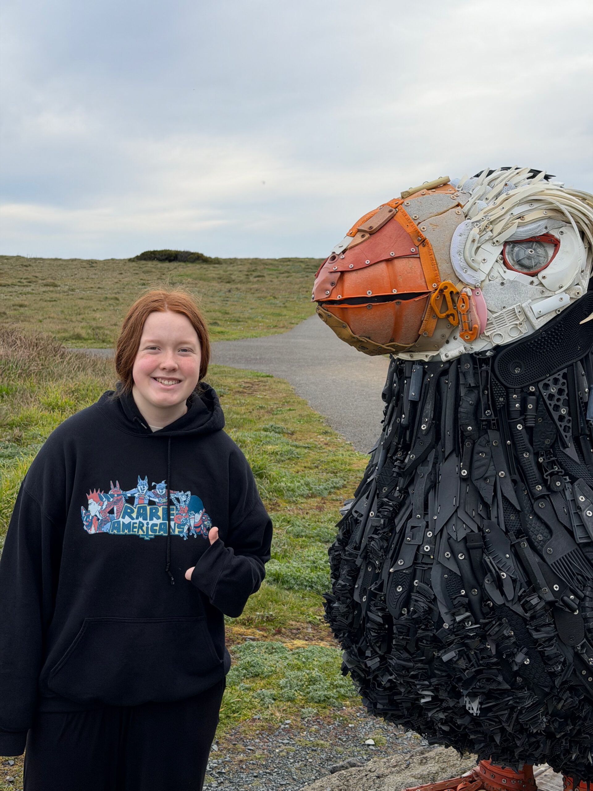 Cami standing next to a giant Washed Ashore seabird sculpture in Bandon, Oregon.
