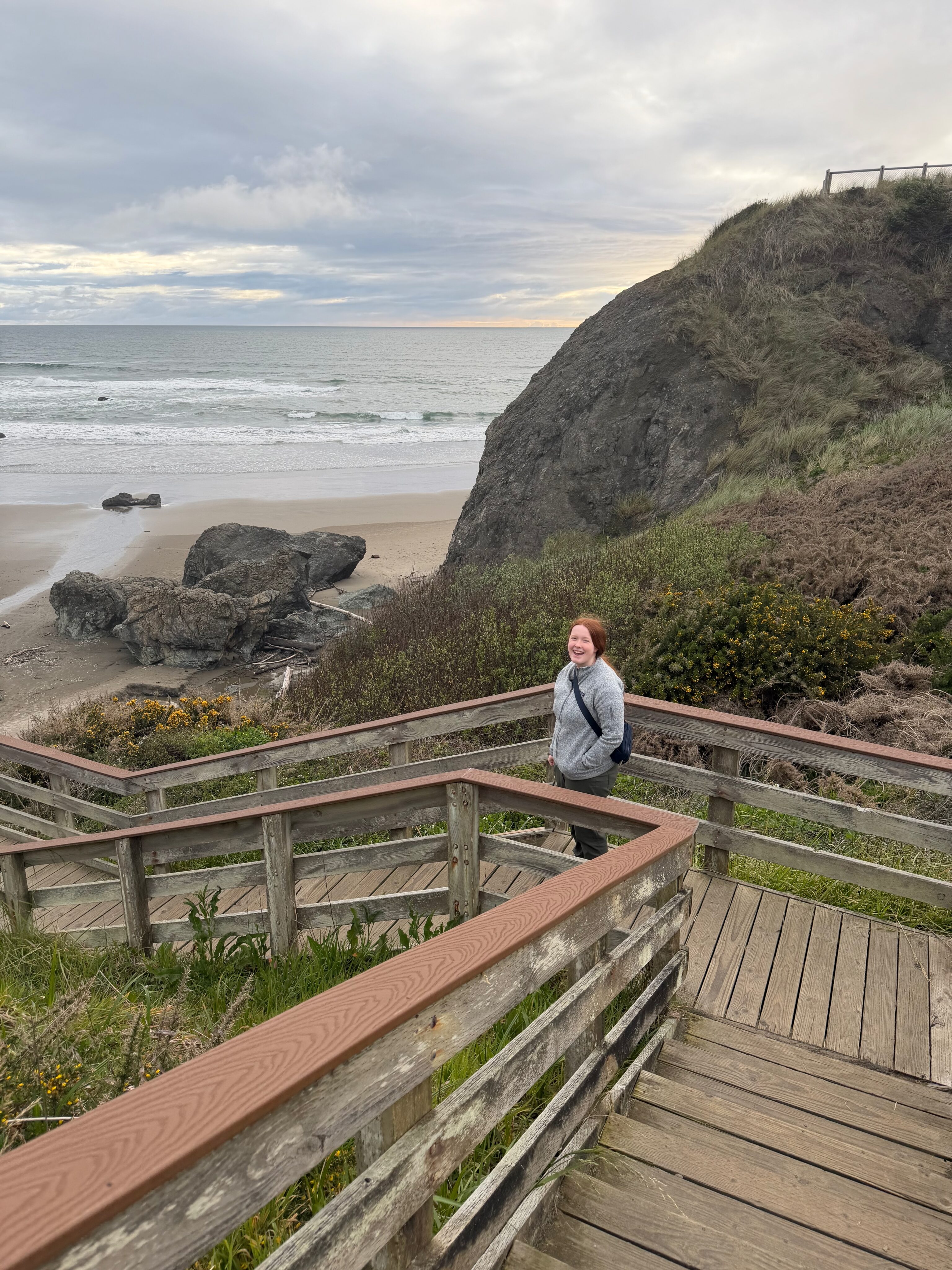 Cami walking down the wooden stairs toward Bandon Beach.