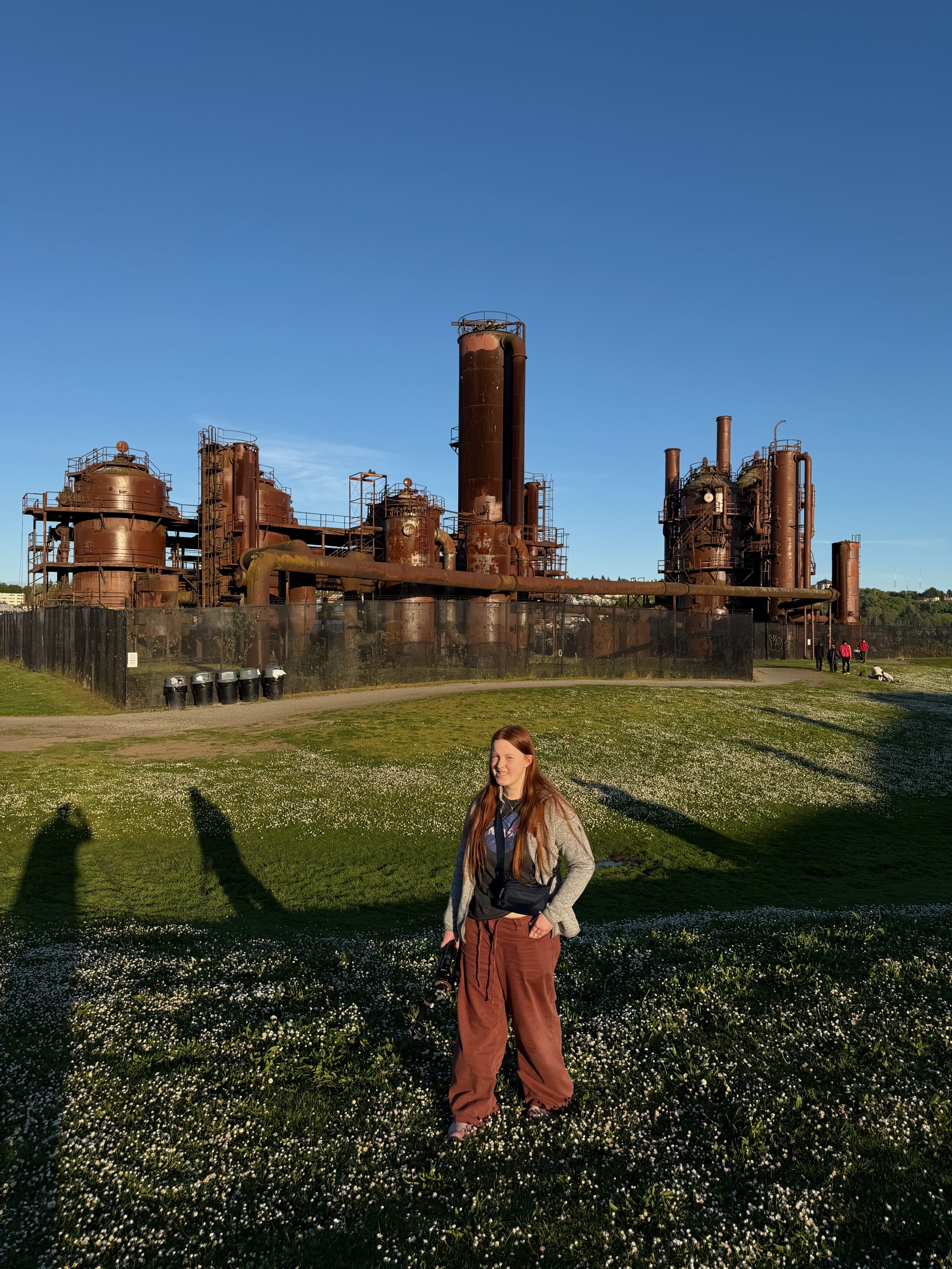 Cami standing at Gas Works Park in Seattle with the old industrial structures behind her.