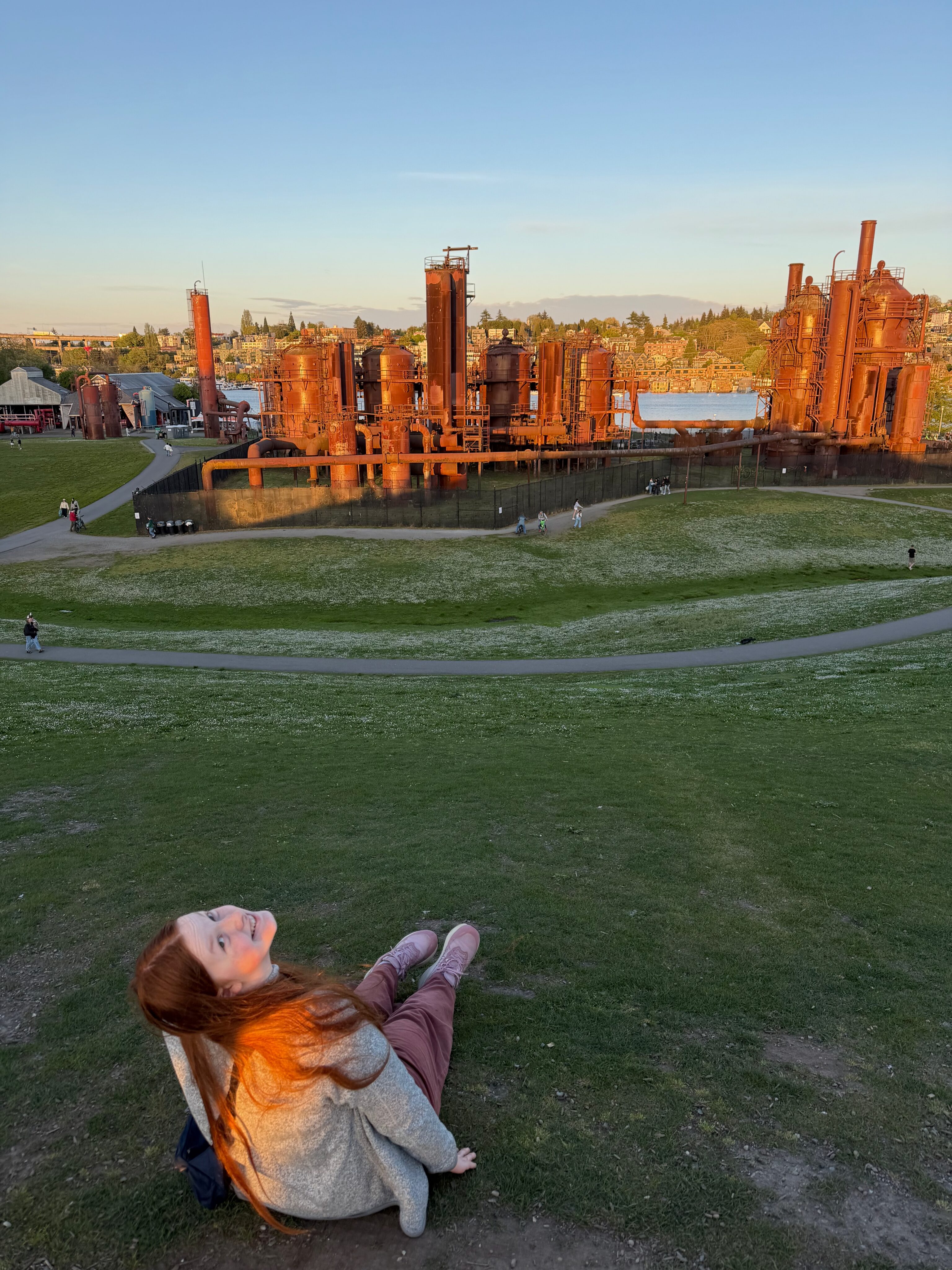 Cami sitting in the grass during golden hour at Gas Works Park in Seattle.