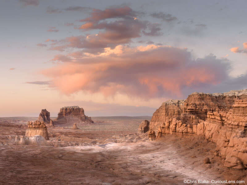 Blue hour landscape in Goblin Valley State Park, Utah, with soft pastel clouds above sandstone cliffs and desert rock formations.